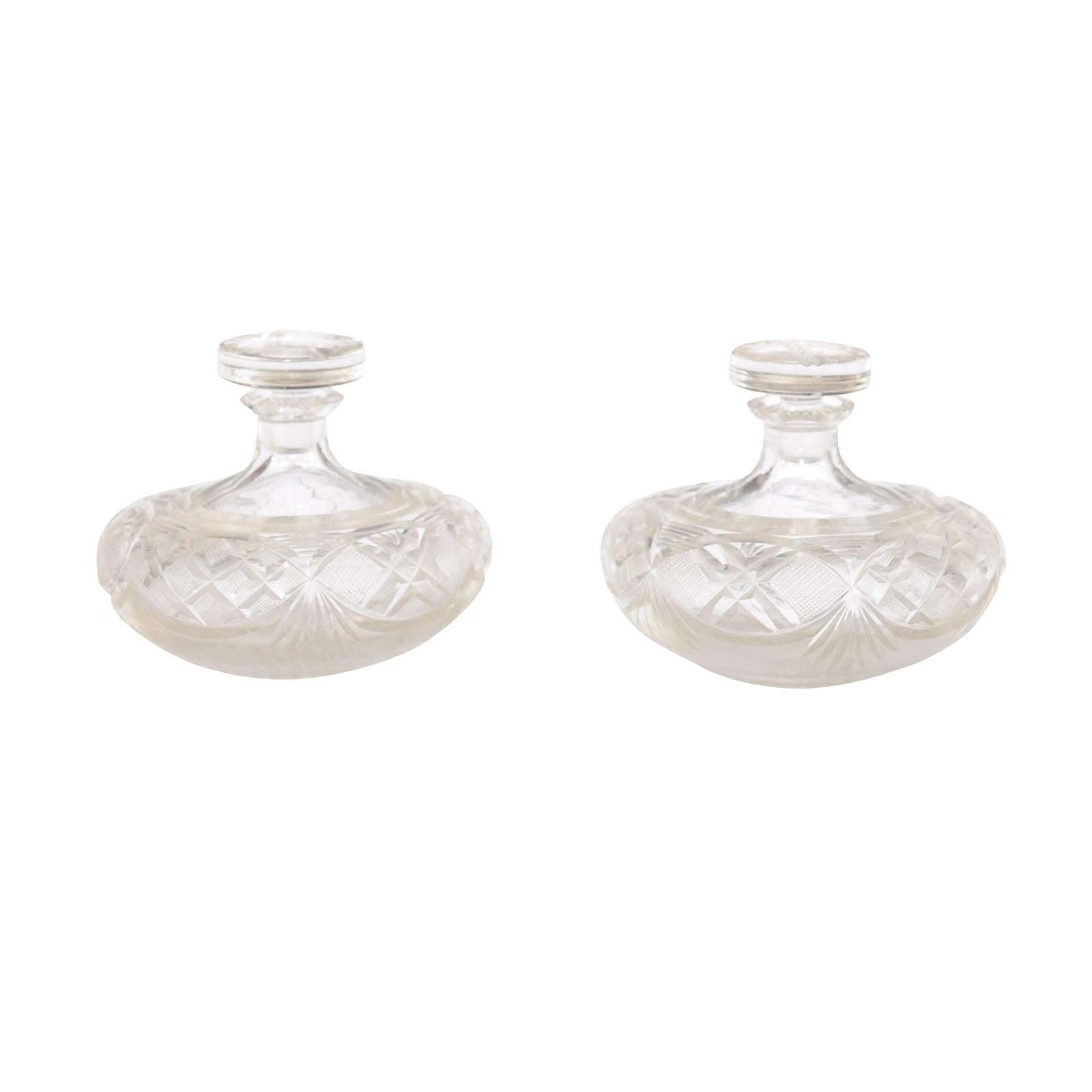 A pair of French Baccarat Crystal perfume bottles from the 19th century with stoppers and cutaway motifs. A pair of French Baccarat Crystal perfume bottles from the 19th century, exuding opulence and timeless elegance with their exquisite cutaway