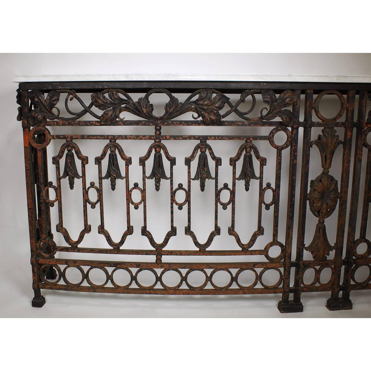 A Large Pair of French 19th Century Baroque Style Free-Standing Serpentine Wrought Iron Wall Console Tables with marble top. The slender bowed wrought iron bodies surmounted with leaf and flower ornaments on an architectural frame with a black paint