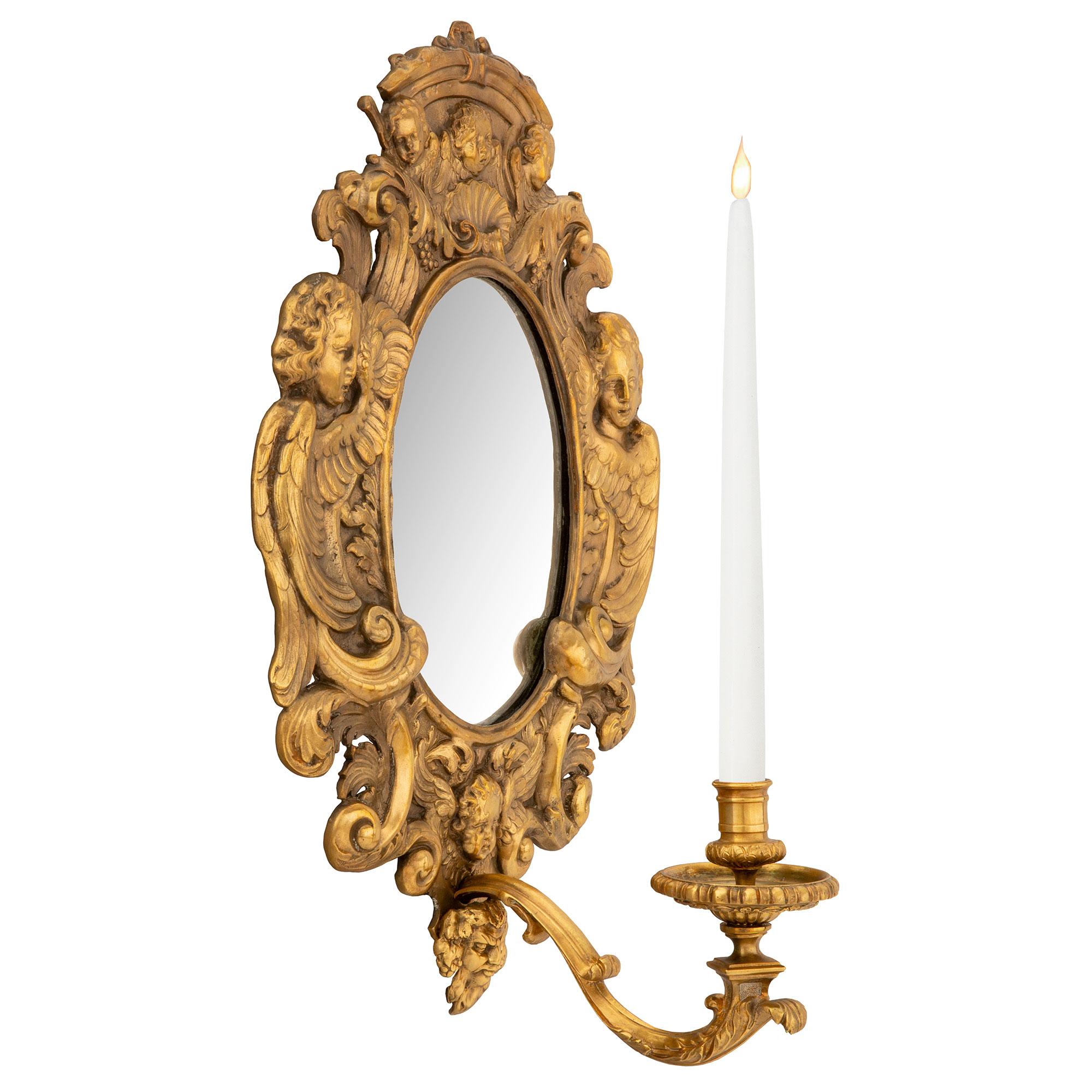An elegant pair of French 19th century Baroque st. ormolu mirrored sconces. Each sconce is centered by a single finely scrolled arm adorned with a large acanthus leaf leading to the reeded candle cup. At the bases are richly chased bearded satyrs