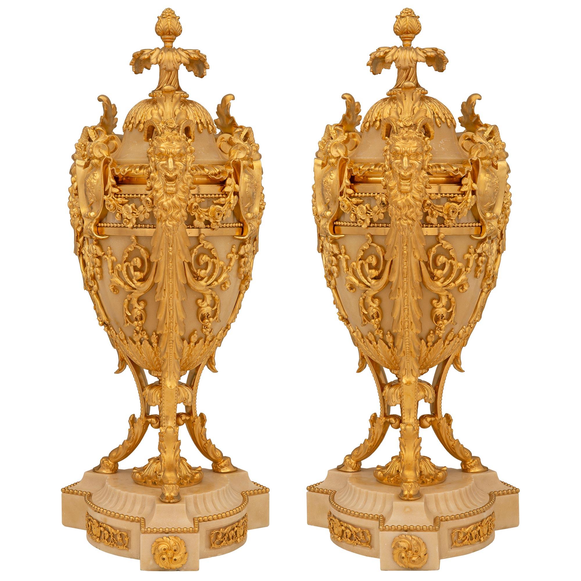 A sensational and extremely high quality pair of French 19th century Louis XVI st. Belle Époque period Alabaster and ormolu urns. Each urn is raised by a beautiful fluted Alabaster base with cut corners and adorned with most decorative ormolu