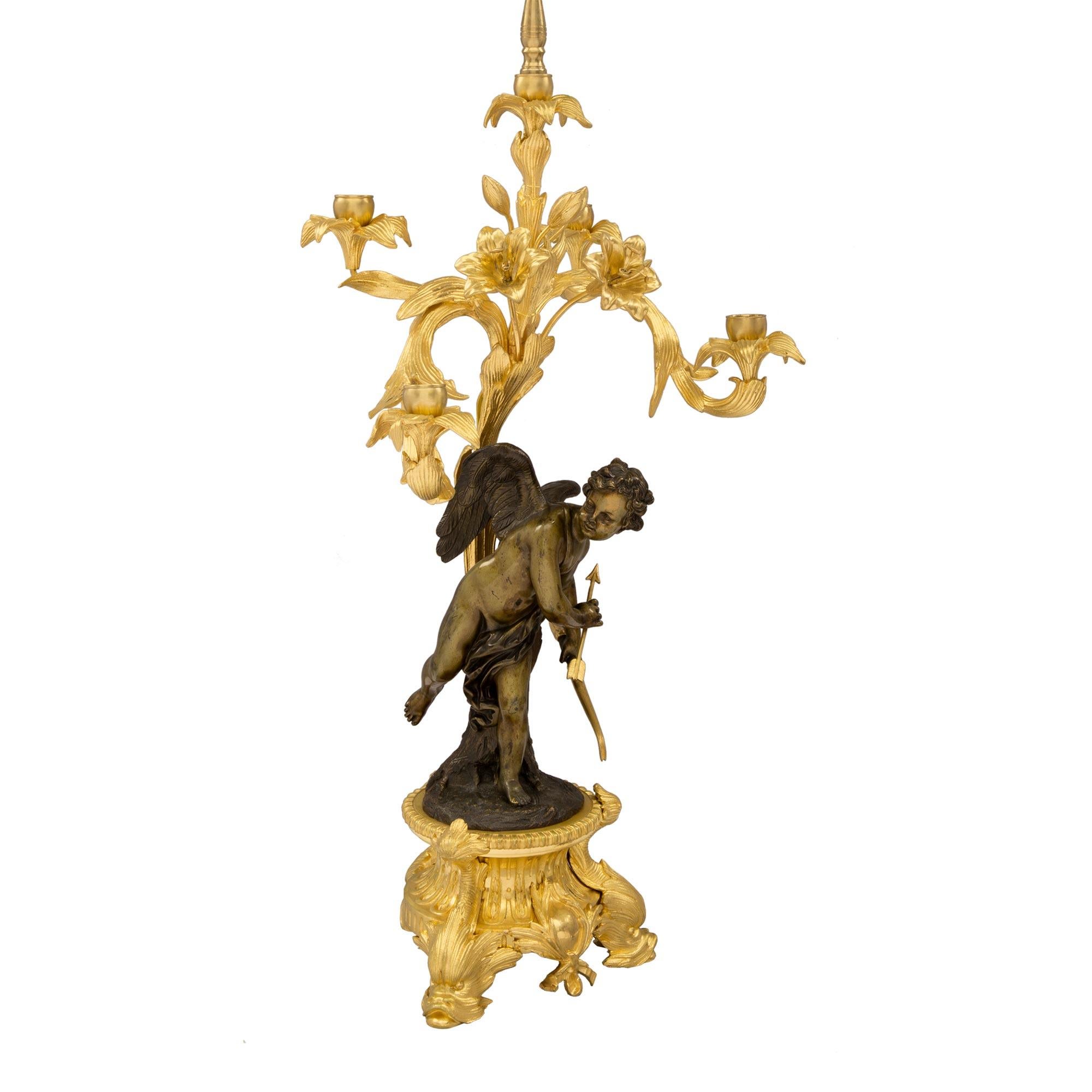 A spectacular pair of French 19th century Belle Époque period, five arm ormolu and patinated bronze, candelabras attributed to Henry Picard. Each lamp is raised by a circular ormolu base with impressive dolphins, a central cabochons amidst foliate