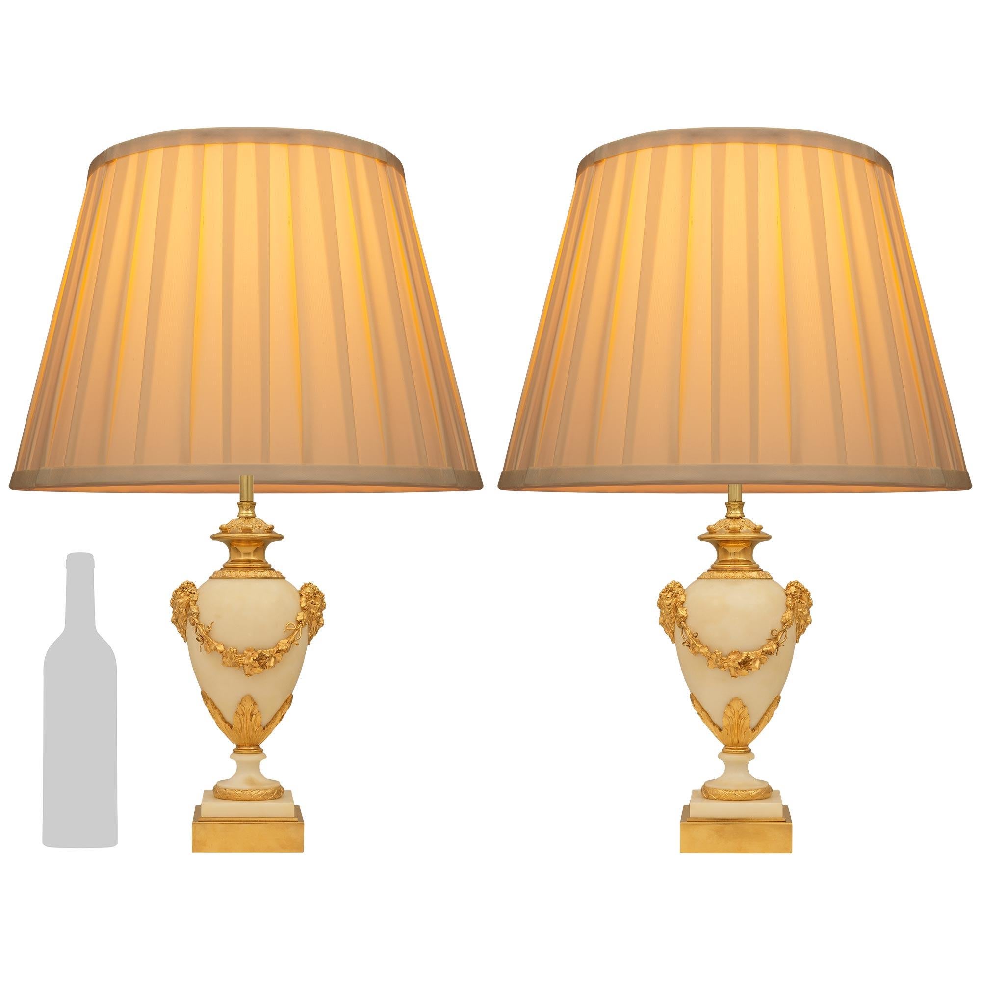 Una coppia elegante e di alta qualità di lampade francesi del XIX secolo in stile Belle Epoque in marmo bianco di Carrara e Ormolu. Ogni splendida urna montata in una lampada è sollevata da una base quadrata in Ormolu sotto il supporto in marmo