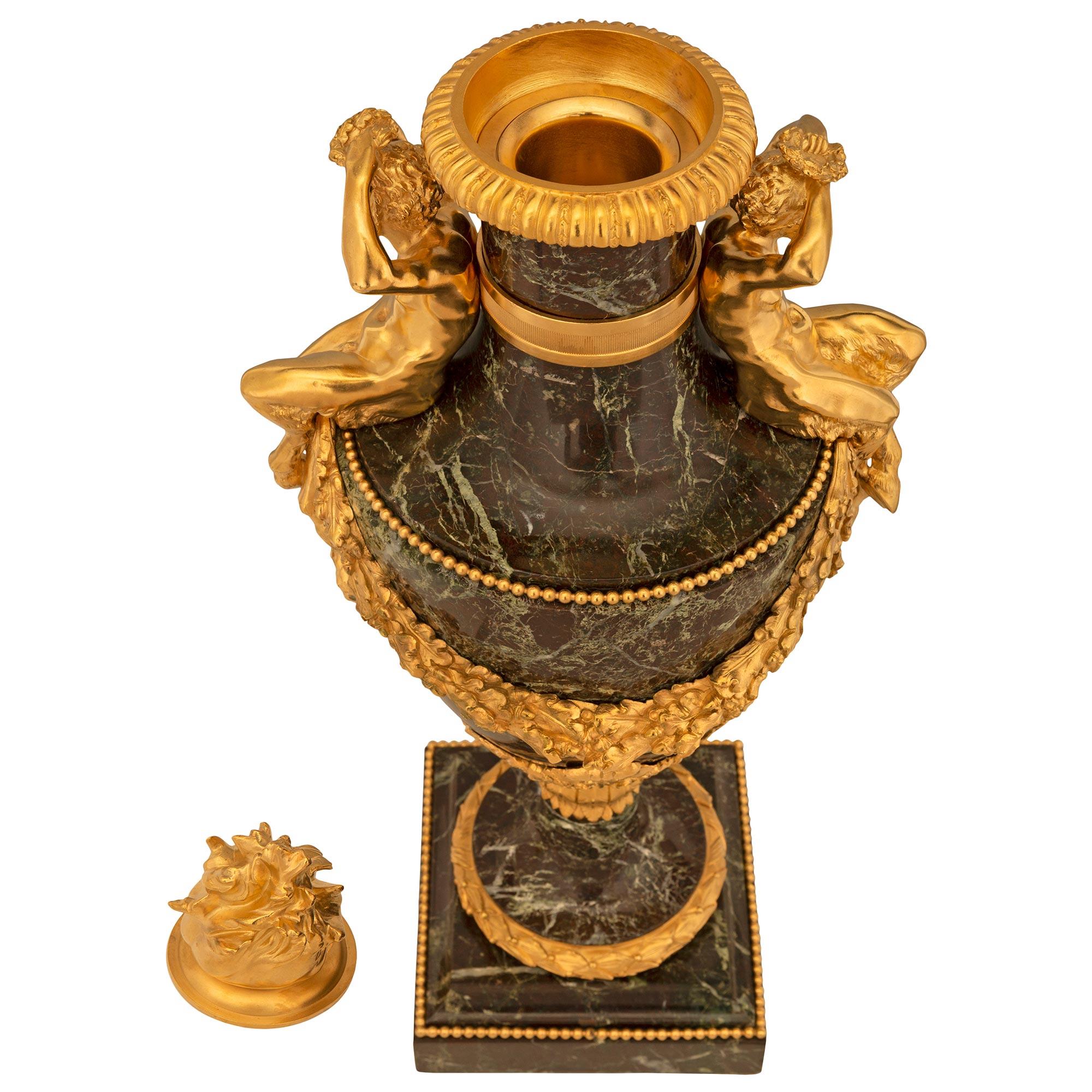 A magnificent and very high quality pair of French 19th century Louis XVI st. Belle Époque period Rosso Levanto marble and ormolu lidded urns. Each urn is raised by a square base with a fine mottled border, wrap around beaded band, and berried
