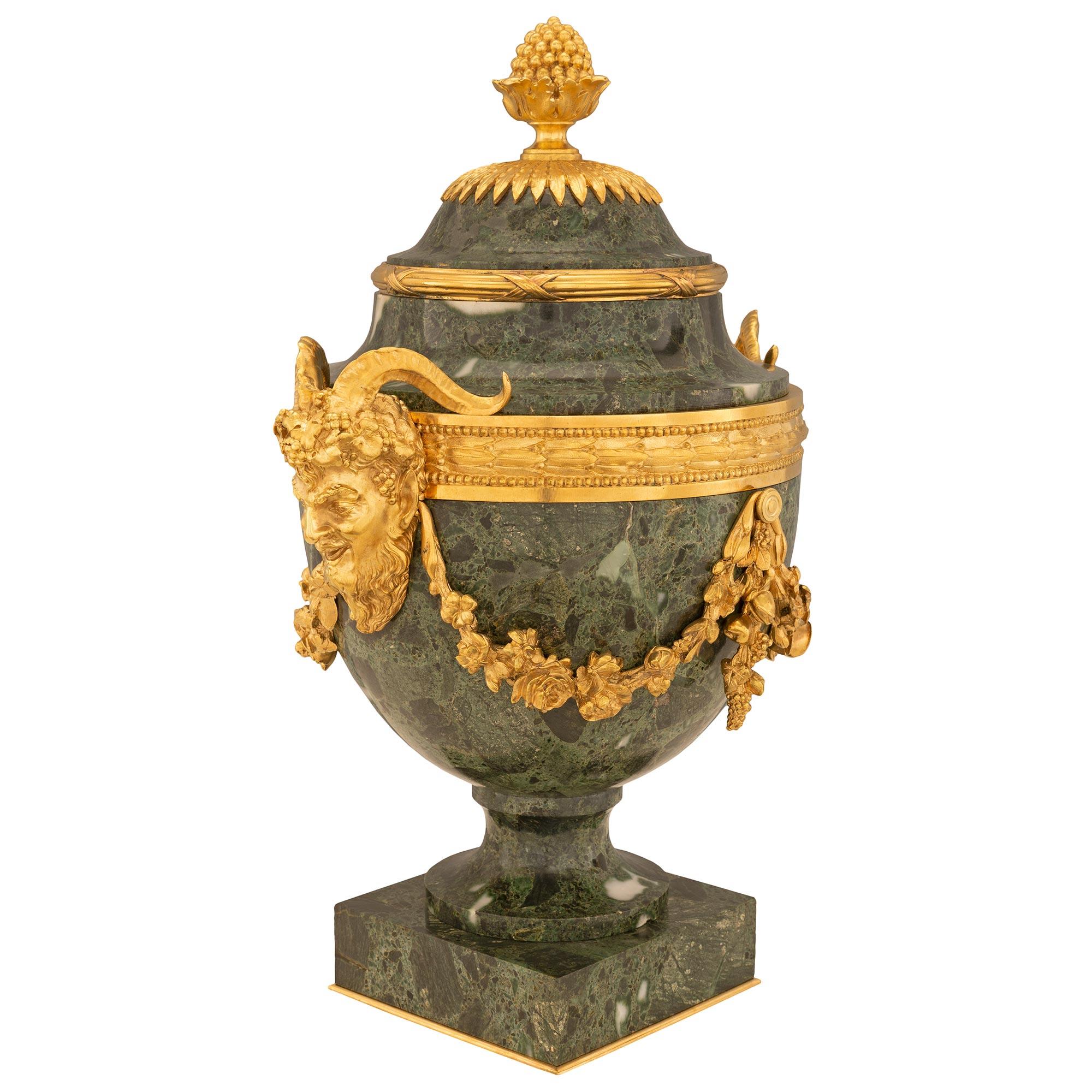 A striking and high quality pair of French 19th century Louis XVI st. Belle Époque period Vert Antique marble and ormolu urns. Each urn is raised by a square marble base with a fine bottom ormolu band below the elegantly curved socle shaped pedestal