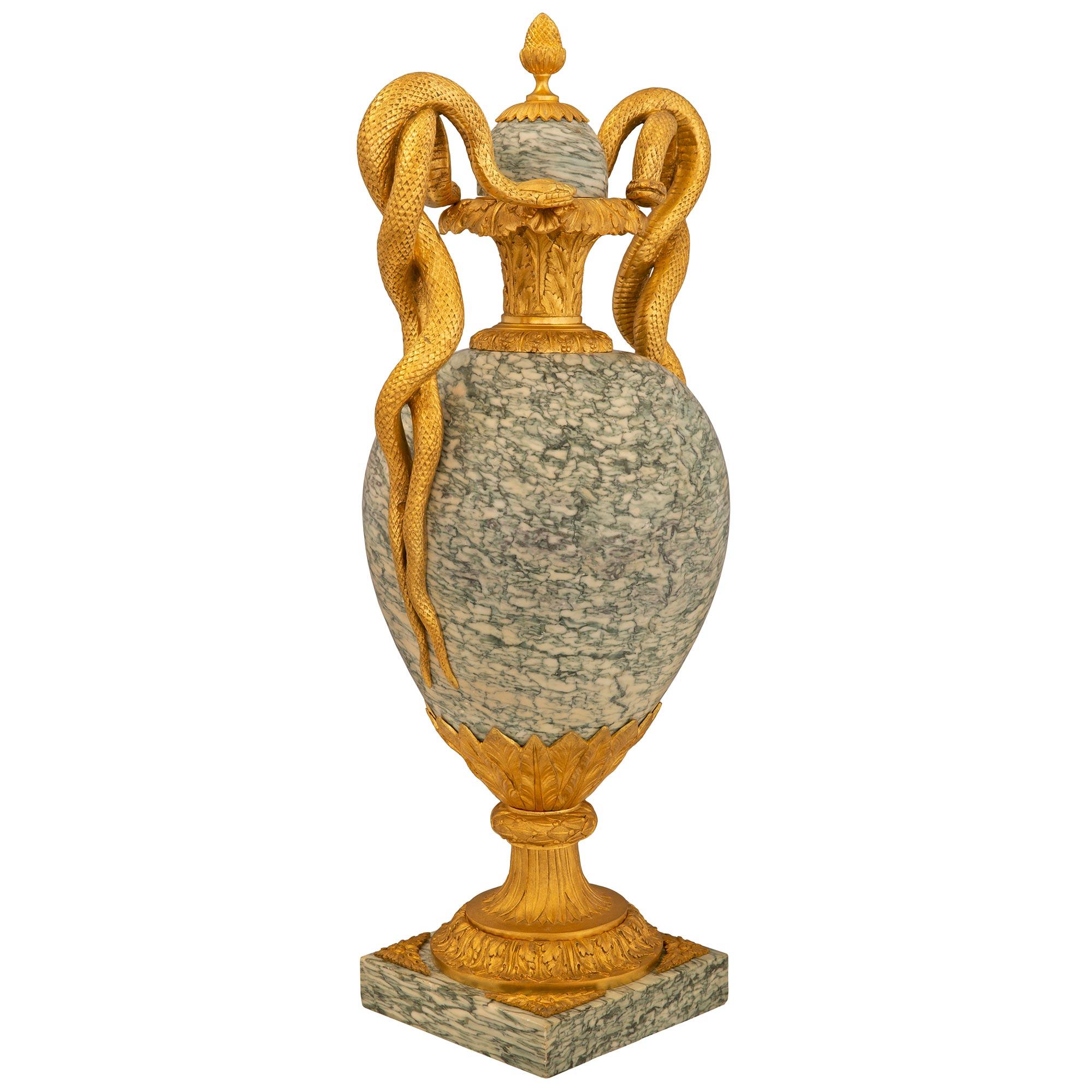 A stunning and very high quality pair of French 19th century Louis XVI st. Belle Époque period ormolu and Vert Campan marble lidded urns. Each urn is raised by a square Vert Campan marble base with fine foliate accents and a most elegant socle