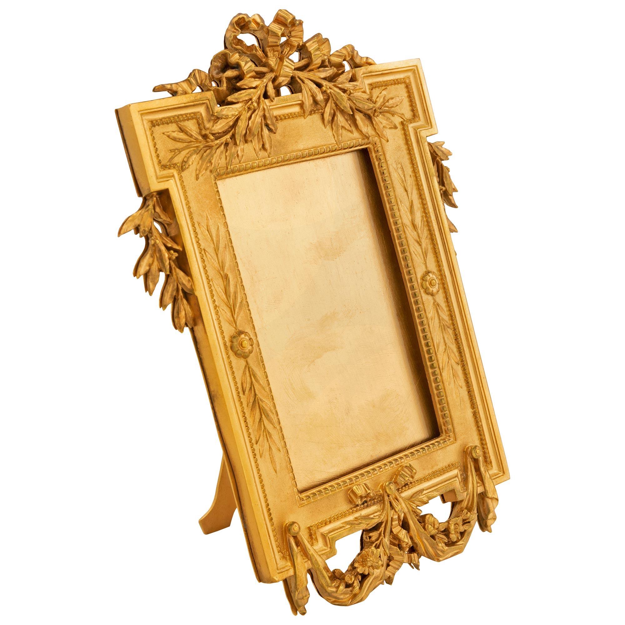 A beautiful and extremely high quality pair of French 19th century Louis XVI St. Belle Époque period ormolu picture frames signed and stamped Christofle. Each free standing picture frame displays beautiful intricately detailed swaging fabric