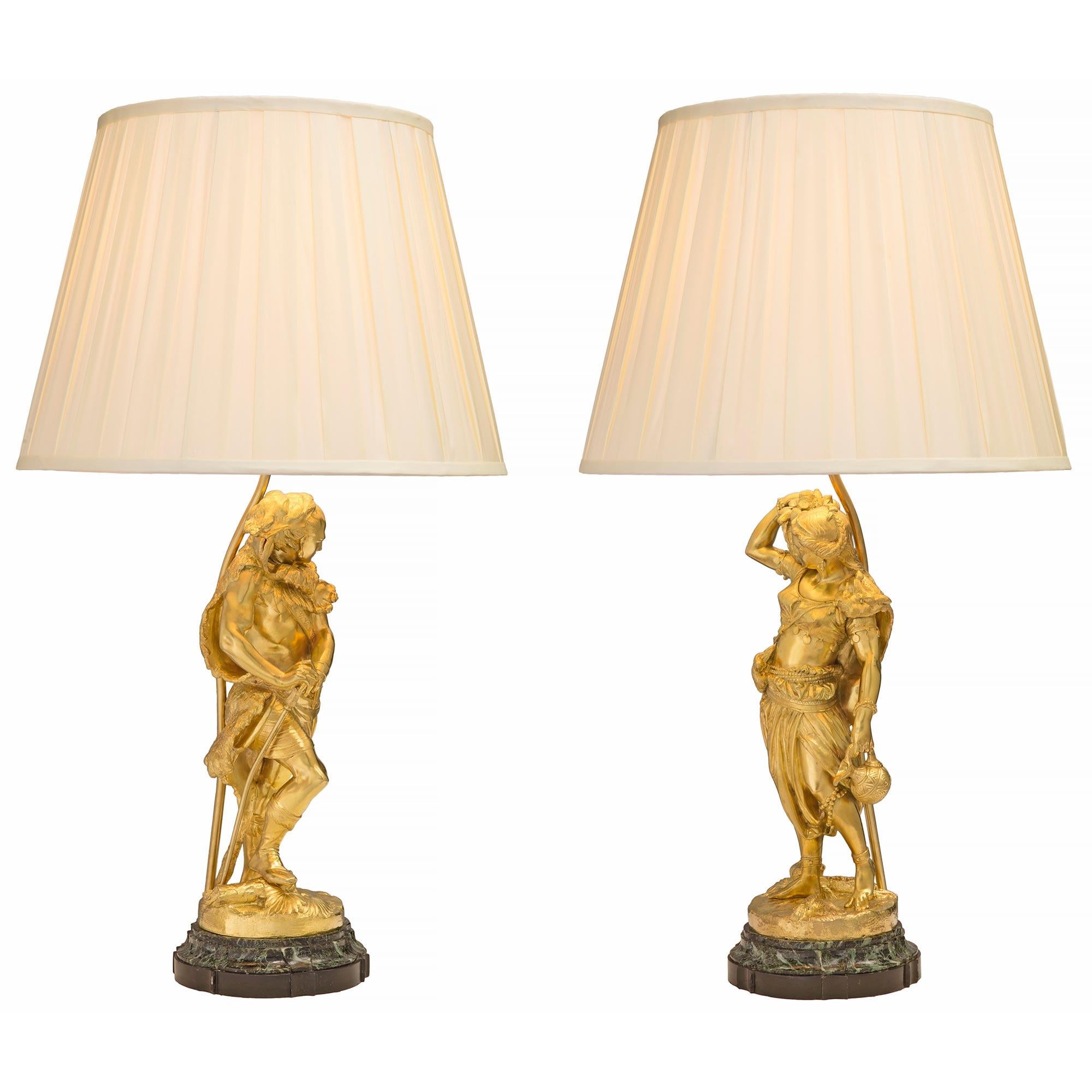 A stunning and high quality true pair of French 19th century Louis XVI st. Belle Époque period ormolu and Vert de Patricia marble statues mounted into lamps. Each lamp is raised by a most uniquely mottled and scalloped patinated bronze and Vert de