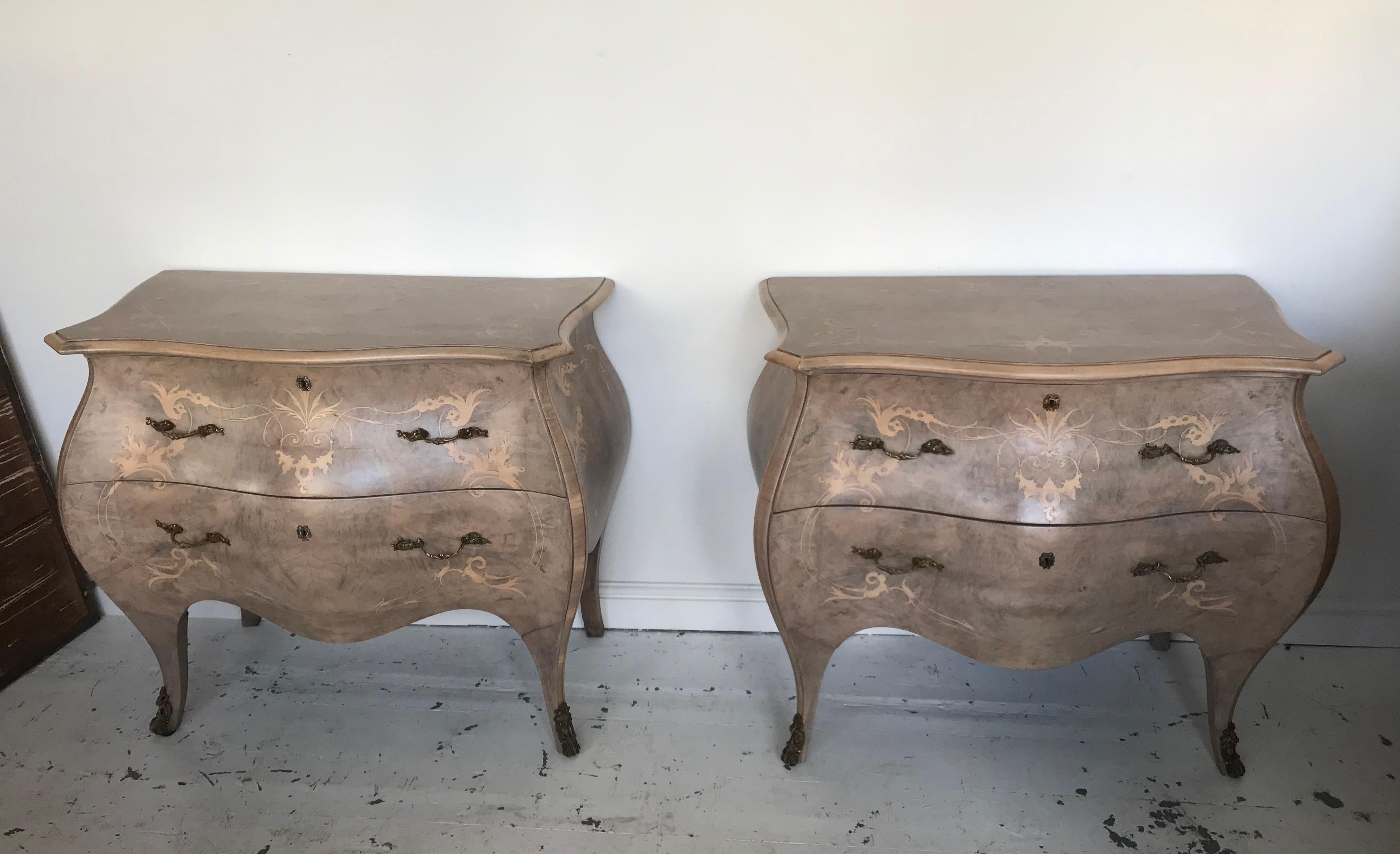 Pair of French Bombe Commodes in bleached walnut with ormolu mounts. Inlaid scroll decoration complete with keys for the locks. Unusual bleached warm color and very stylish.