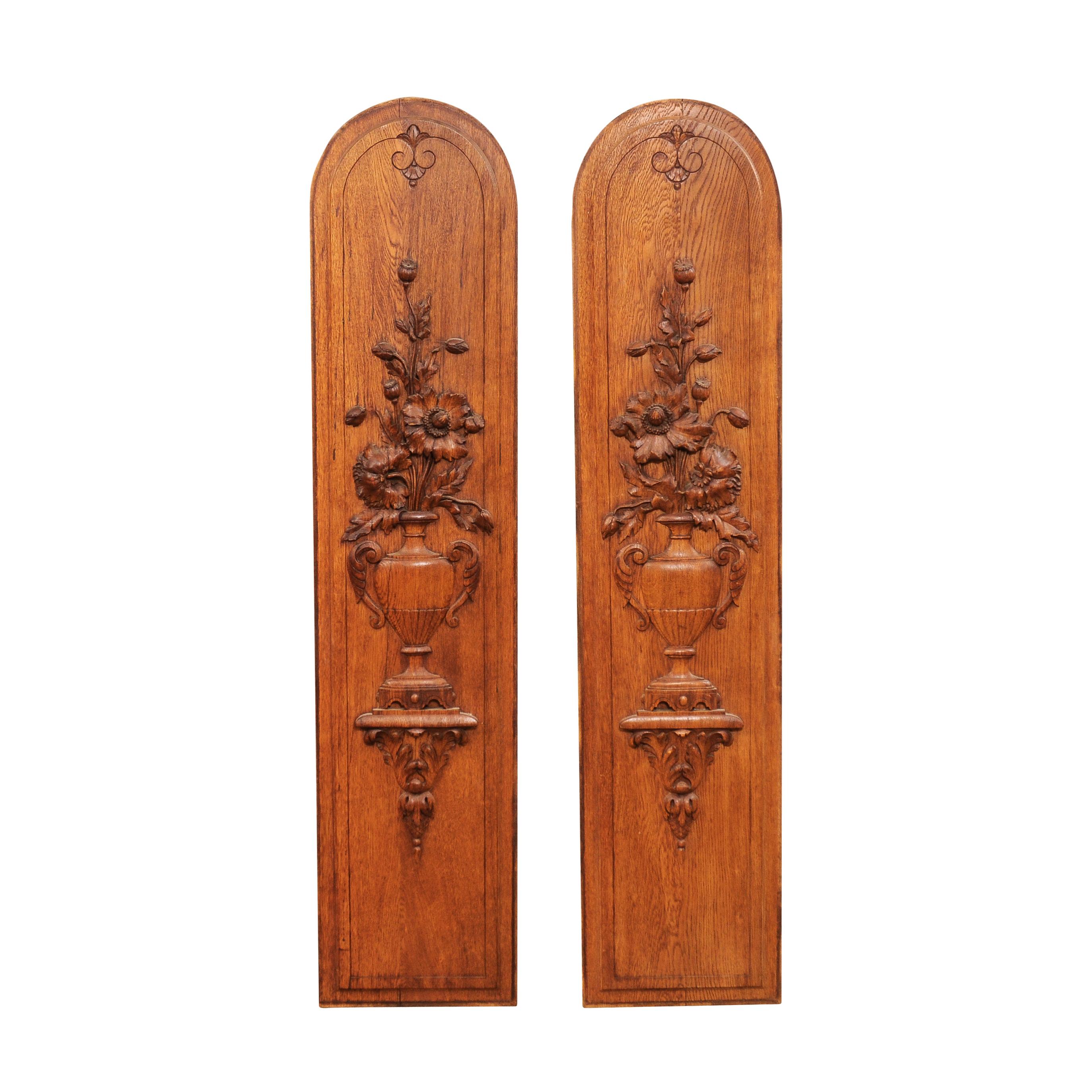 A pair of French oak vertical decorative panels from the 19th century with carved bouquets in vases. Enhance your interior with this stunning pair of French oak vertical decorative panels from the 19th century. These exquisite panels are a testament