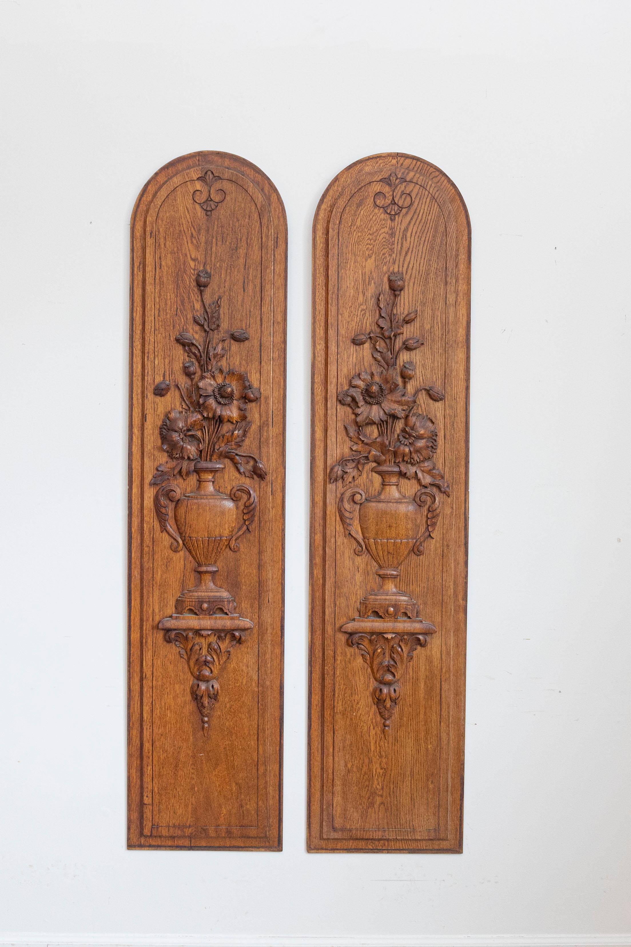 A pair of French oak vertical decorative panels from the 19th century with carved bouquets in vases. Enhance your interior with this stunning pair of French oak vertical decorative panels from the 19th century. These exquisite panels are a testament