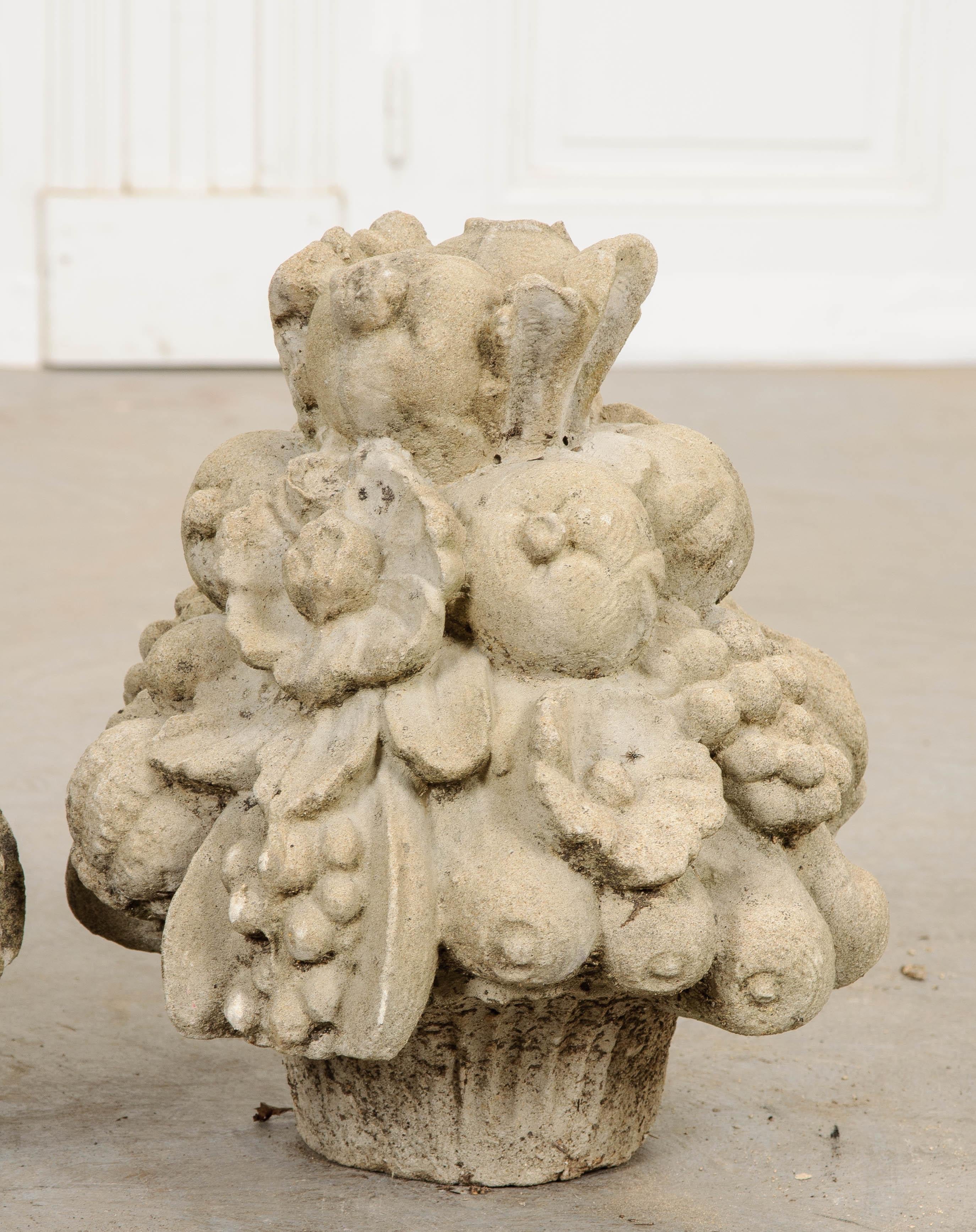 A cornucopia of fruit - cast in stone and piled high - create each of these decorative French finials. Peaches, plums and other stone fruit can be found mixed in with the harvest. Decades of weather have afforded the pair an outstanding patina that