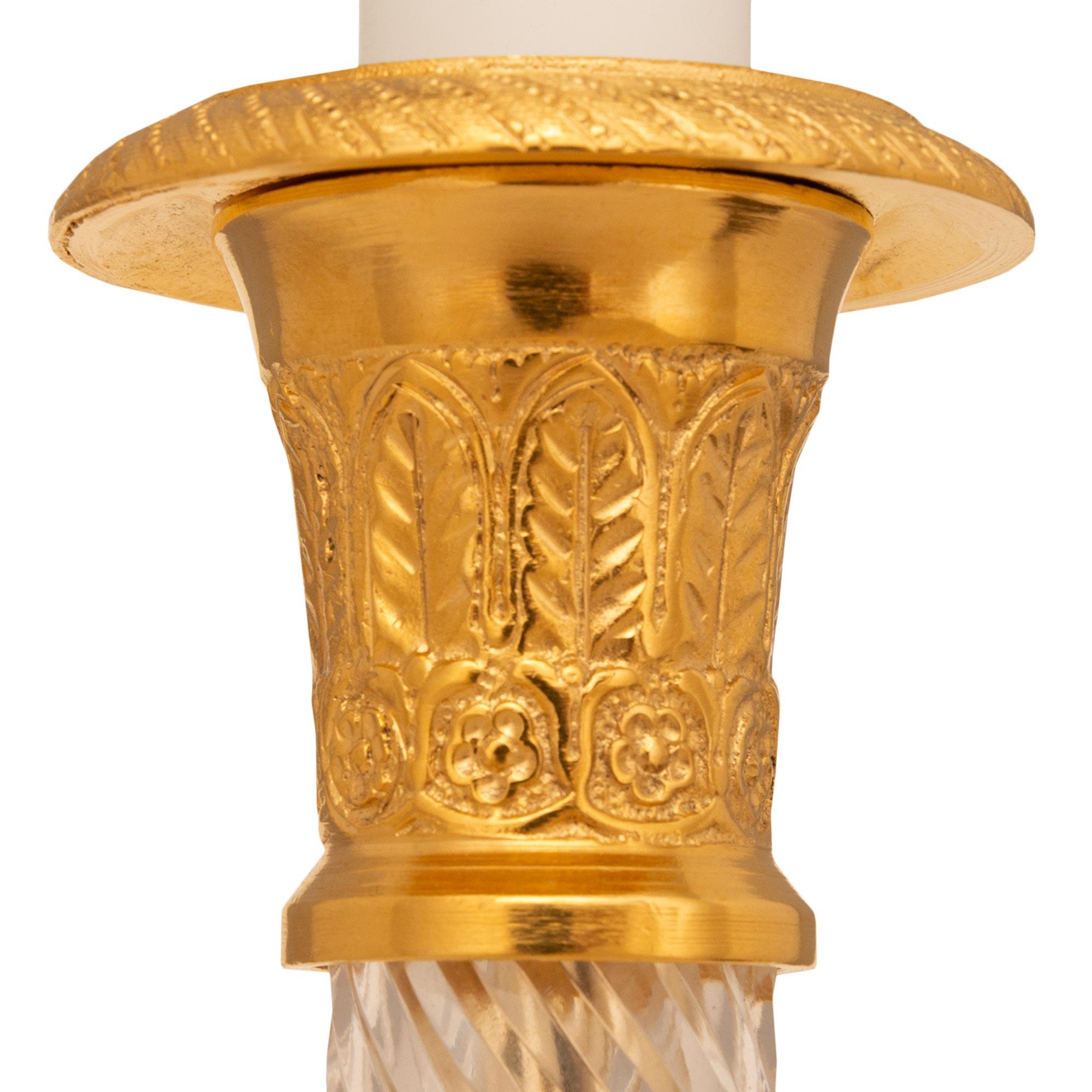Un'elegantissima coppia di lampade a candelabro in ormolu e vetro di Charles X, Francia, XIX secolo. Ogni bellissima lampada a candeliere è sollevata da una base circolare con una bellissima fascia fogliare riccamente cesellata. Sopra il piedistallo