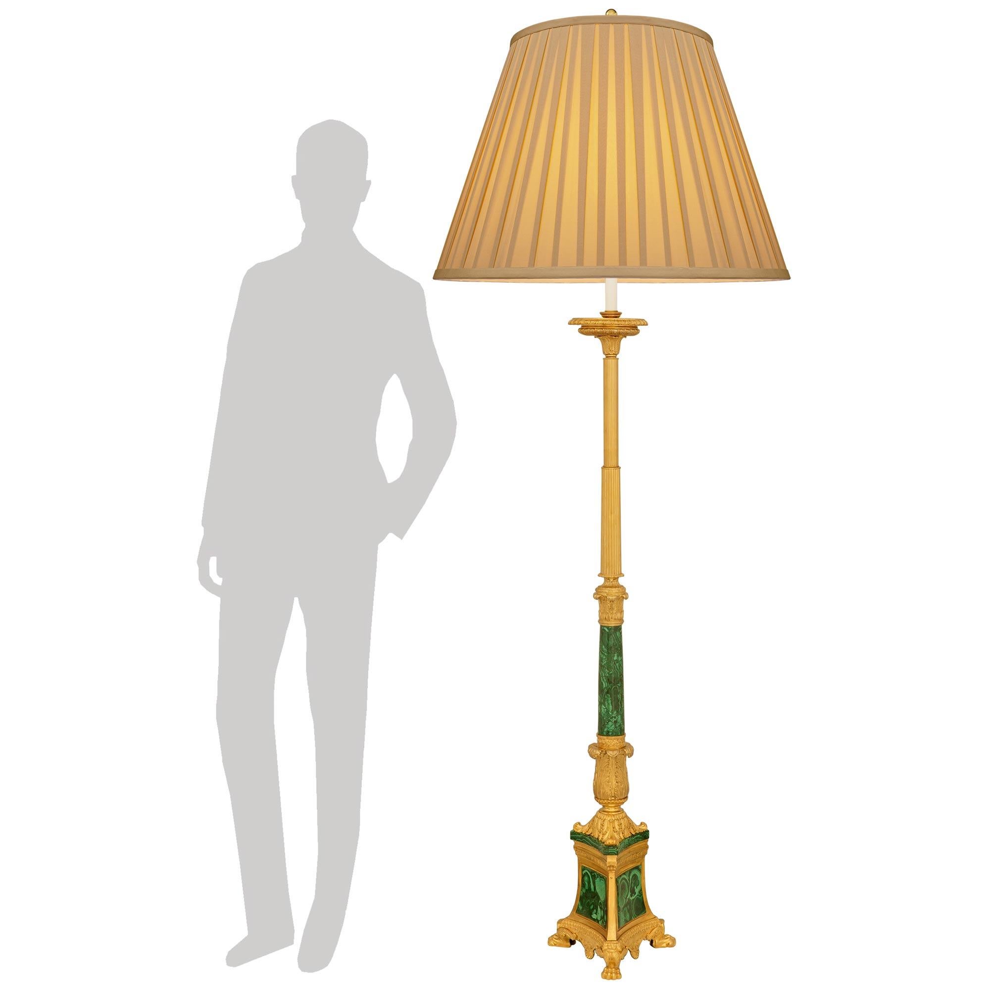 A sensational and high quality pair of French 19th century Charles X st. Ormolu and Malachite floor lamps. This stunning pair of torchières is raised by a striking triangular bases with concave sides, handsome paw feet, and a fine wrap around