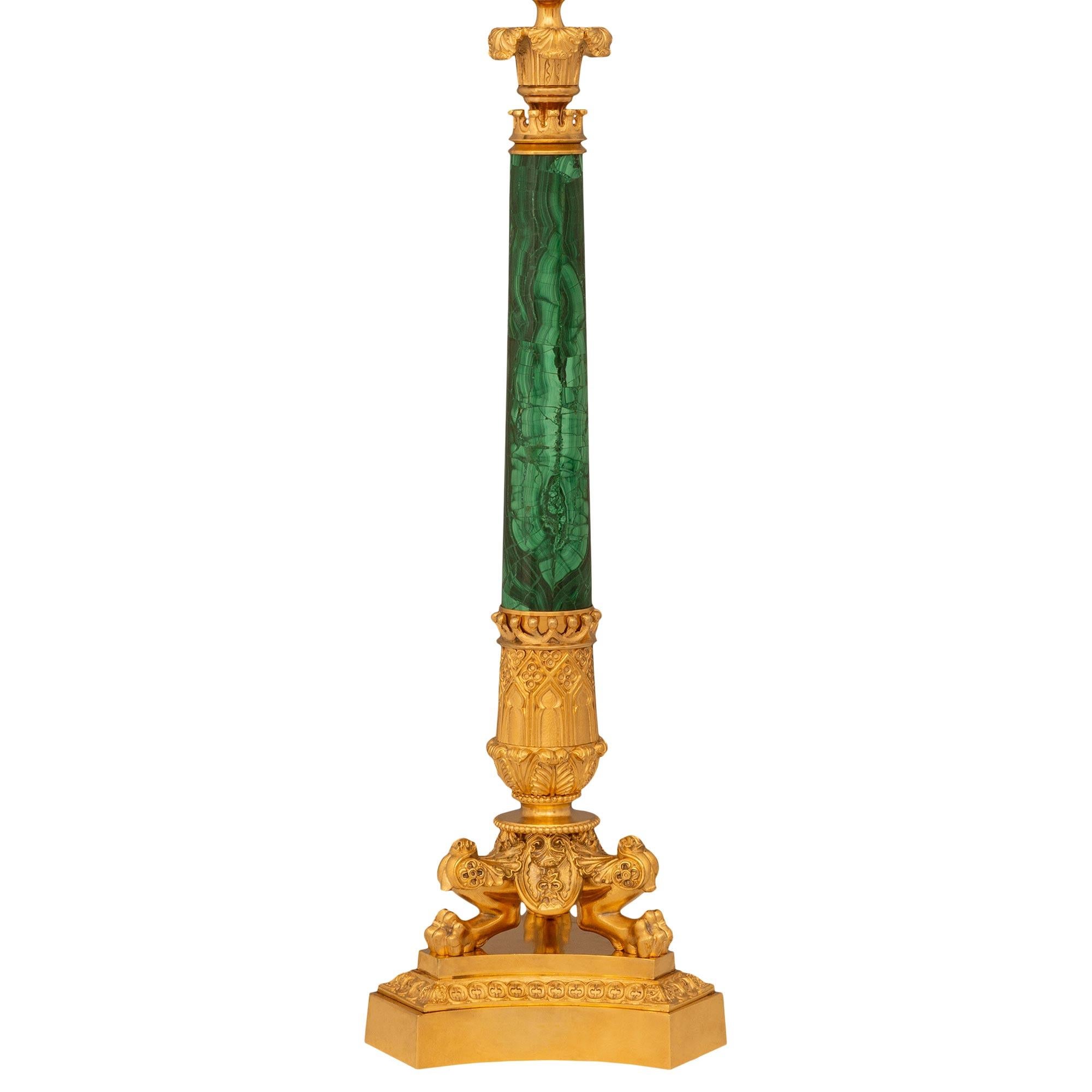 A unique and most decorated pair of French 19th century Charles X st. Ormolu and Malachite lamps. Each lamp is raised by a three sided concave Ormolu base with a mottled band of dentil designs. Above the pedestal, each lamp is supported by three paw