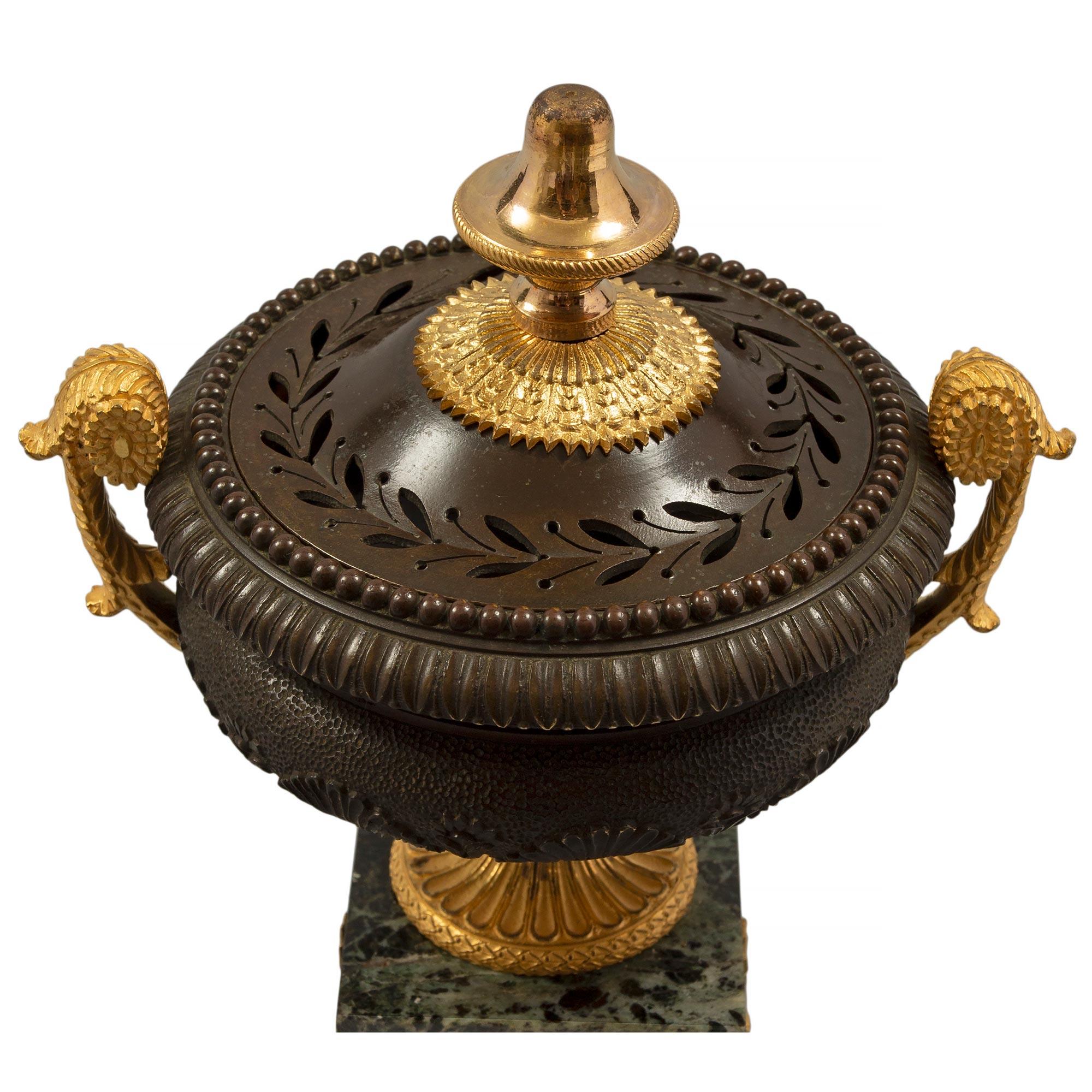 Bellissima coppia di urne pot pourri francesi del XIX secolo in marmo Charles X st. Vert Patricia, ormolu e bronzo patinato. Ogni urna è sollevata da una base quadrata in marmo con una bellissima fascia ormoluta riccamente cesellata. Il supporto