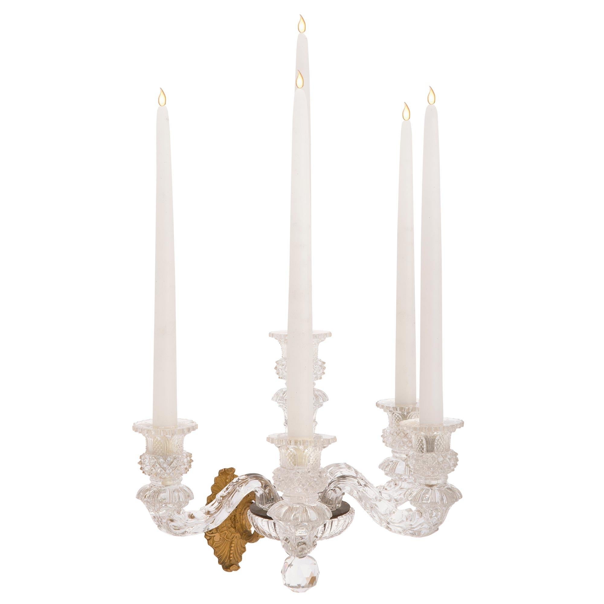 A sensational pair of French 19th century Charles X st. Baccarat crystal and ormolu sconces. Each five arm sconce is centered by a beautiful cut crystal ball below a fine fluted ormolu support and reeded bowl. The ormolu backplates display beautiful