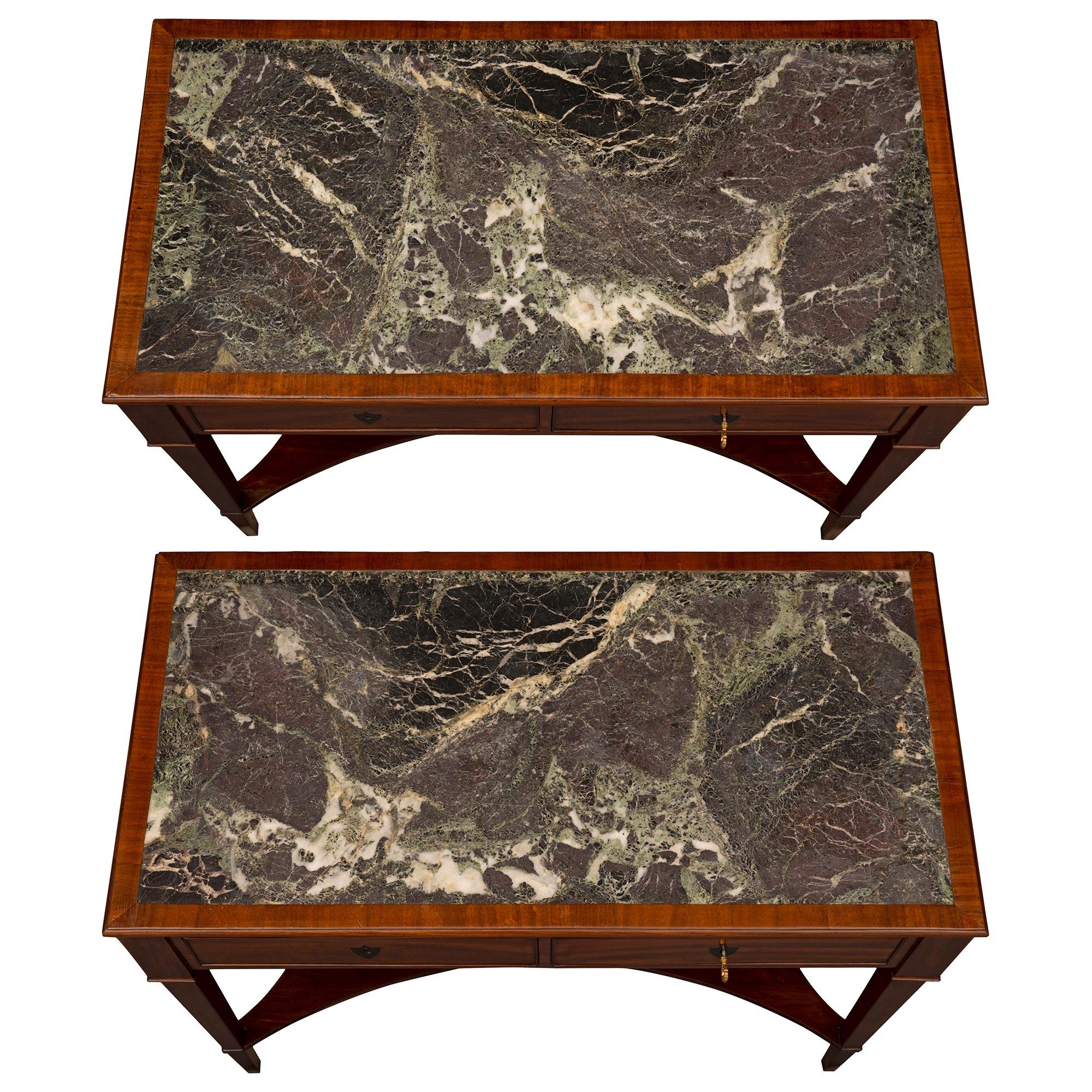 A very elegant pair of French 19th century Directoire st. Mahogany, ebonized Fruitwood, and Vert Maurin marble consoles. Each freestanding console is raised by slender square tapered legs joined by a fine bottom shelf with most decorative concave