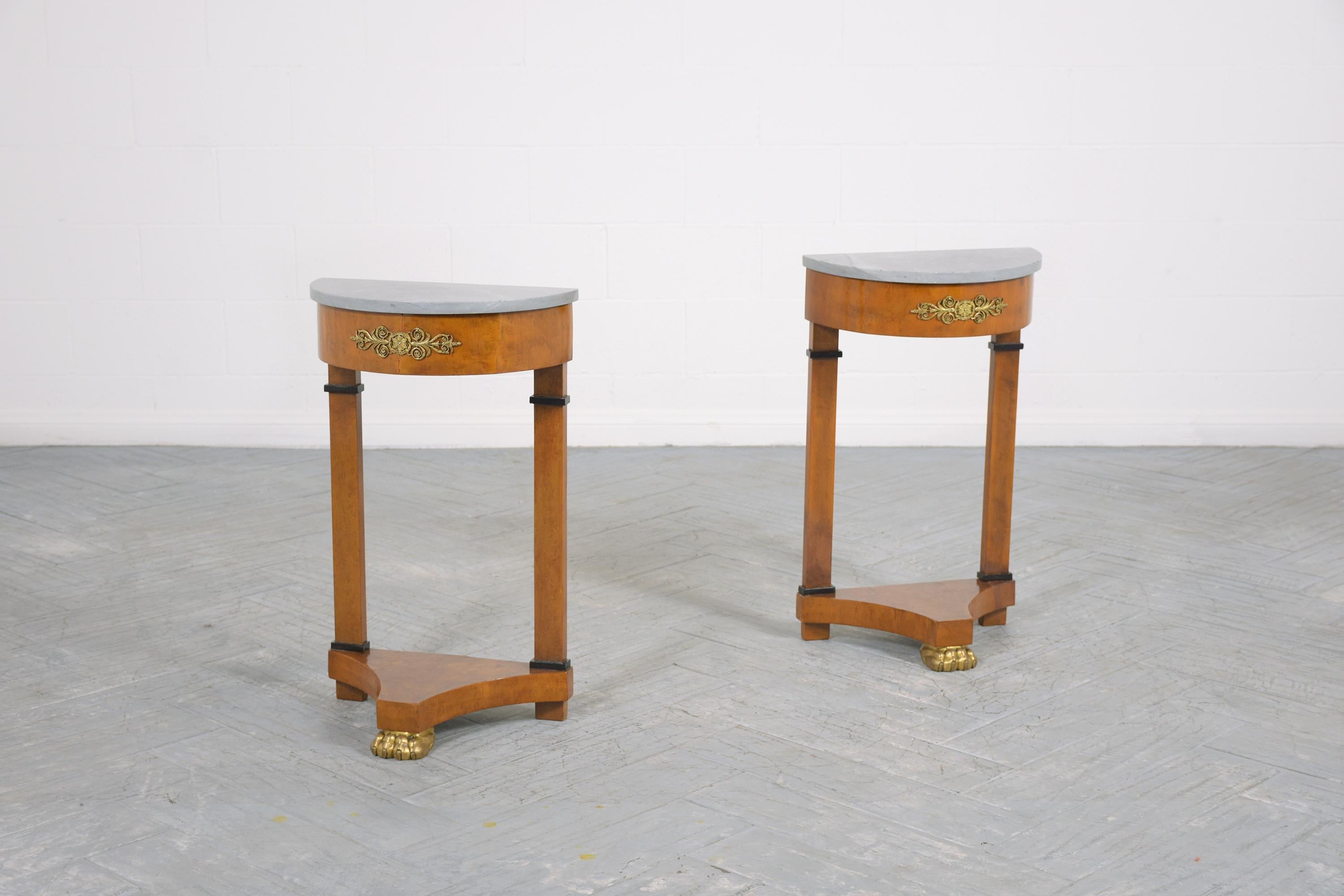 An extraordinary pair of antique demilune Empire side tables are in good condition beautifully crafted out of solid wood covered with a bird’s-eye veneer professionally restored by our professional craftsmen team. This lovely set features its