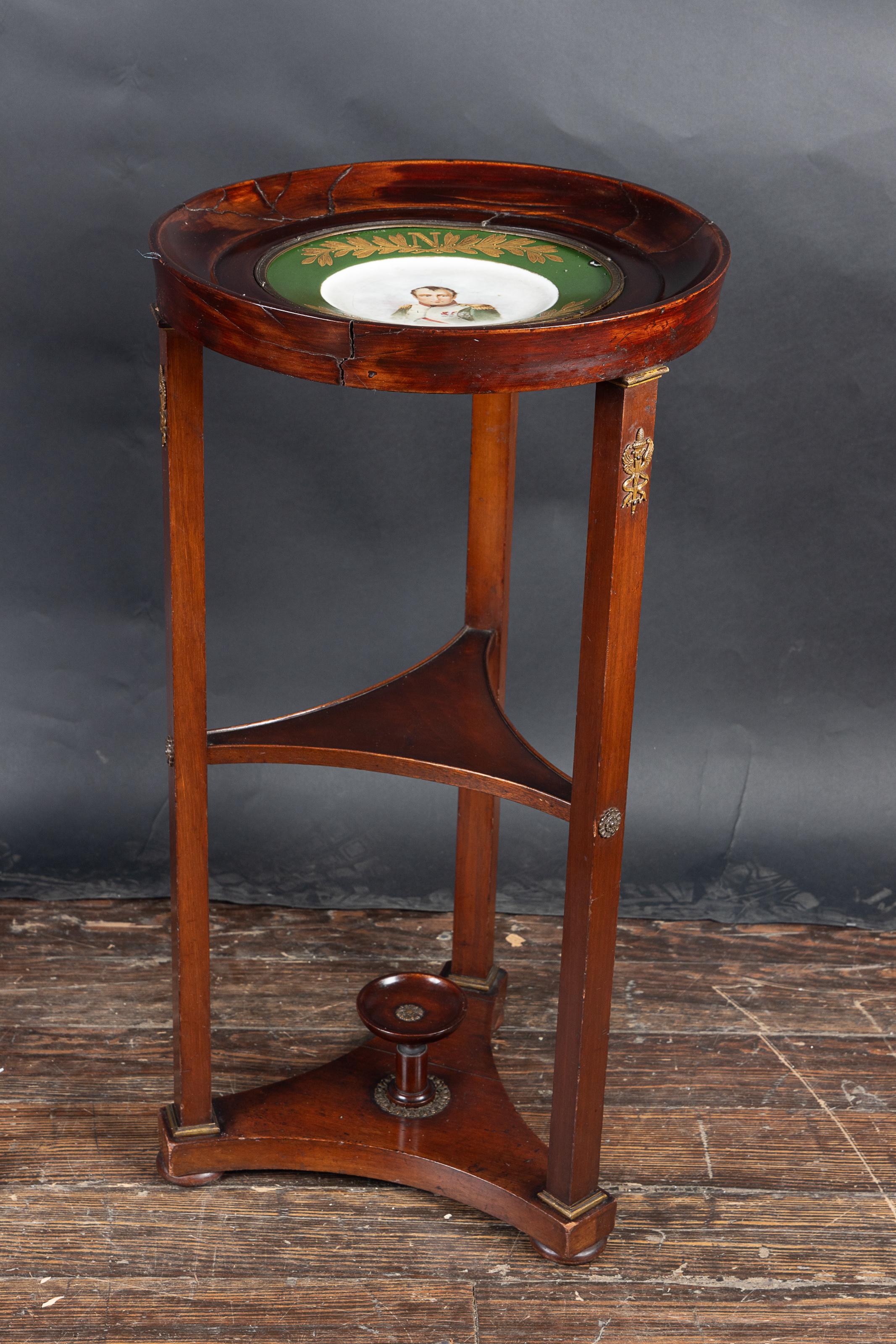 Paar französische runde Mahagonitische in Form eines Empire-Gueridons aus dem 19. Jahrhundert mit drei Ablagen.  

Ein Tisch hat eine massive Holzplatte, der andere eine Platte mit grünem Rand und Goldverzierungen.  Oben befindet sich das 