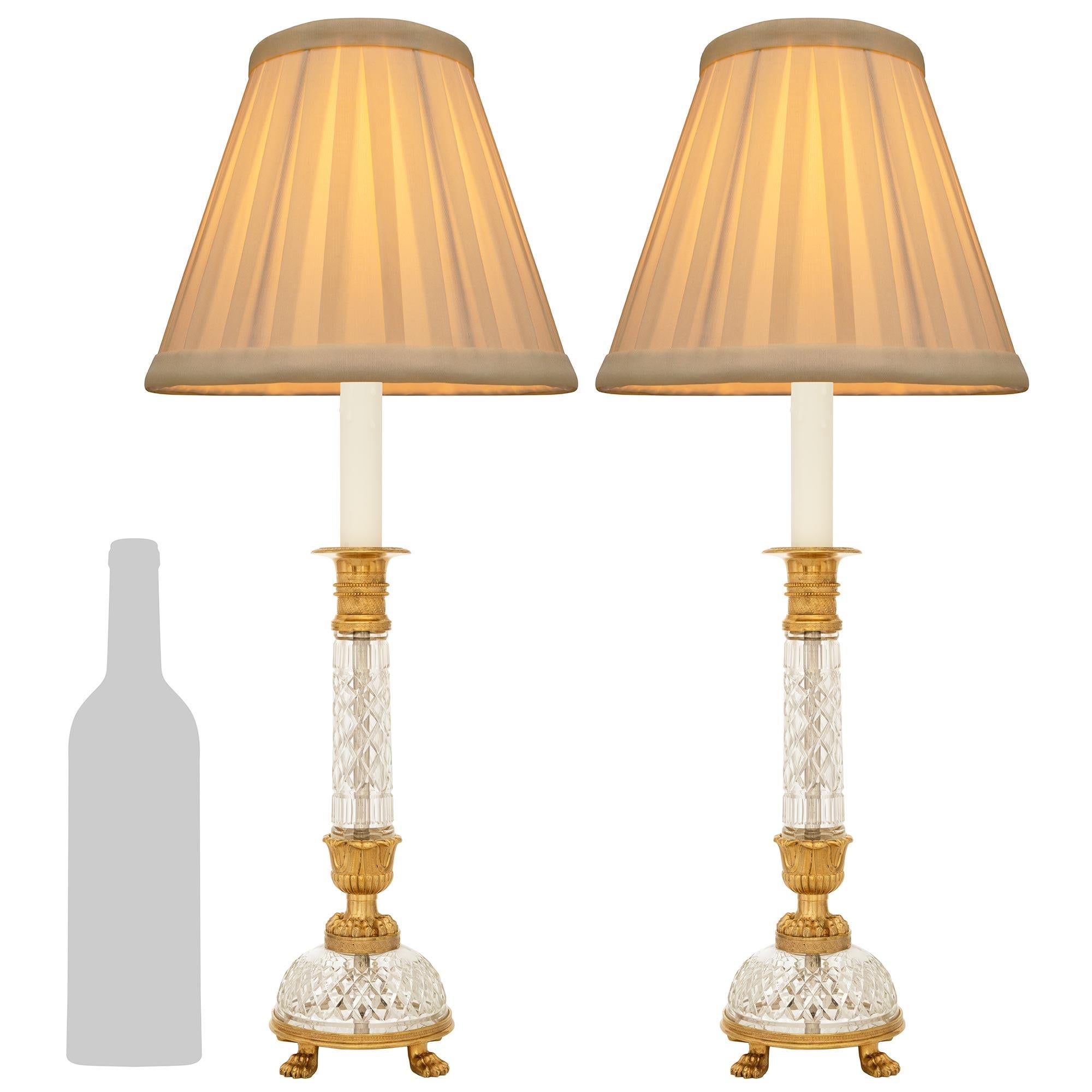 Una coppia elegante e di alta qualità di lampade francesi Eleg del XIX secolo in ormolu e cristallo. Ogni splendido candeliere montato in una lampada è sollevato su quattro zampe di leone in Ormolu sotto una fascia screziata che sostiene la base di