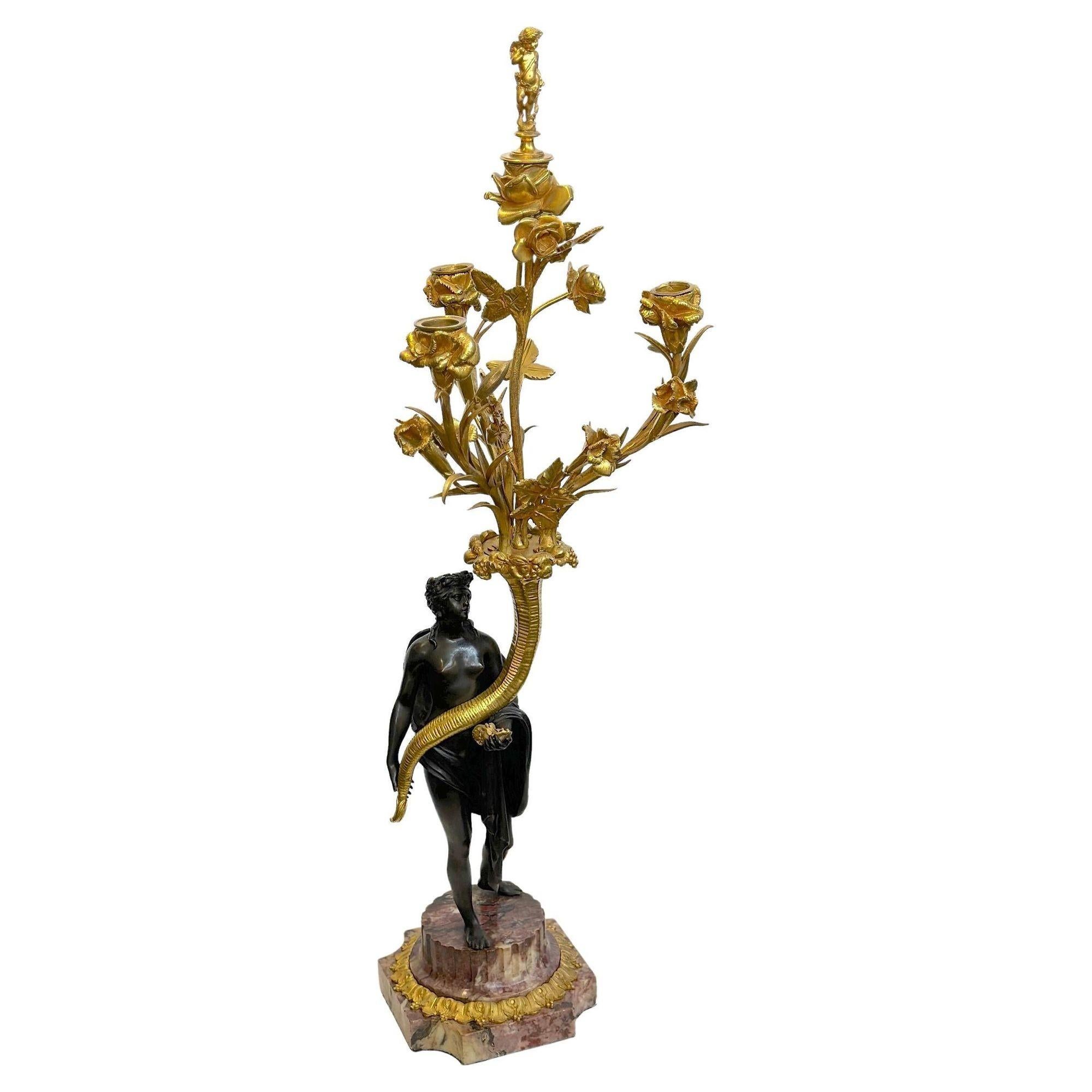Pair of Napoleon III patinated and gilt bronze figural candelabras. Each standing on rouge royal marble bases, the figures appear to be gracefully holding a cornocupia full of flowered branches. Each candelabra also includes a detachable finial on