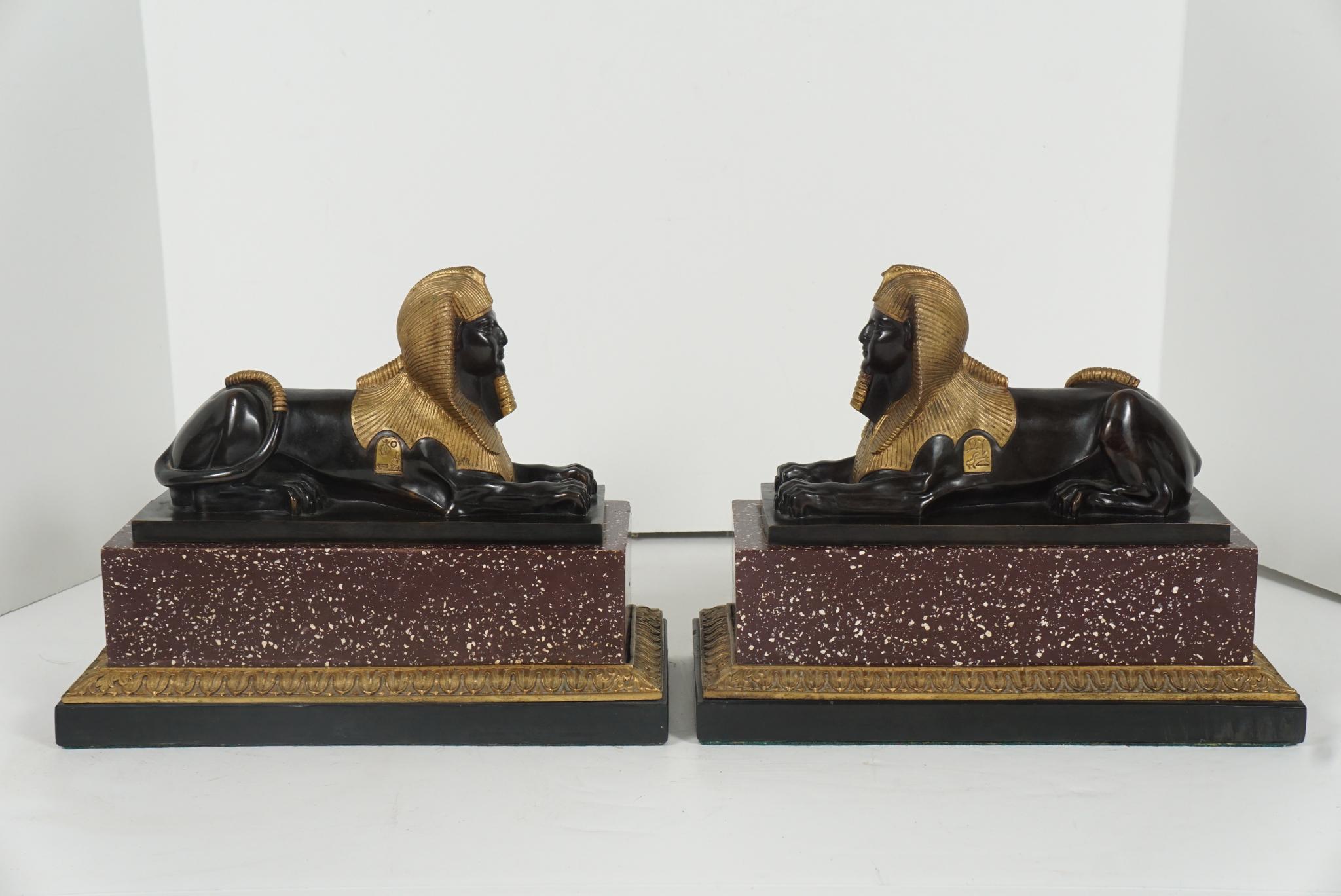 Made in France circa 1840s this finely cast pair of sphinxes are represented in the recumbent position most associated with the form. Showing on both figures are two hieroglyphic cartouches gilded as are the headdress and the ends of their wrapped