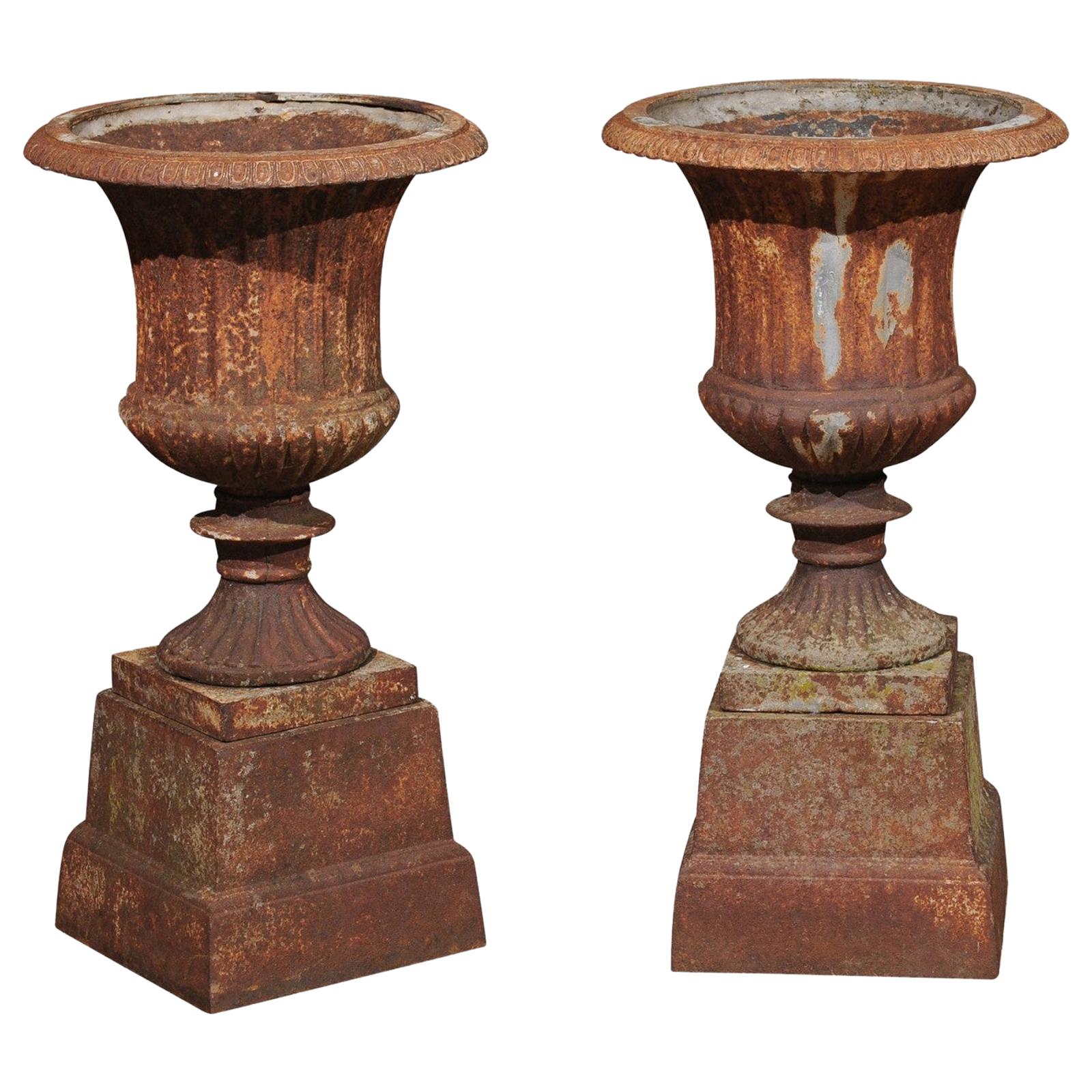 Pair of French 19th Century Iron Médicis Vases on Stepped Pedestals with Patina For Sale