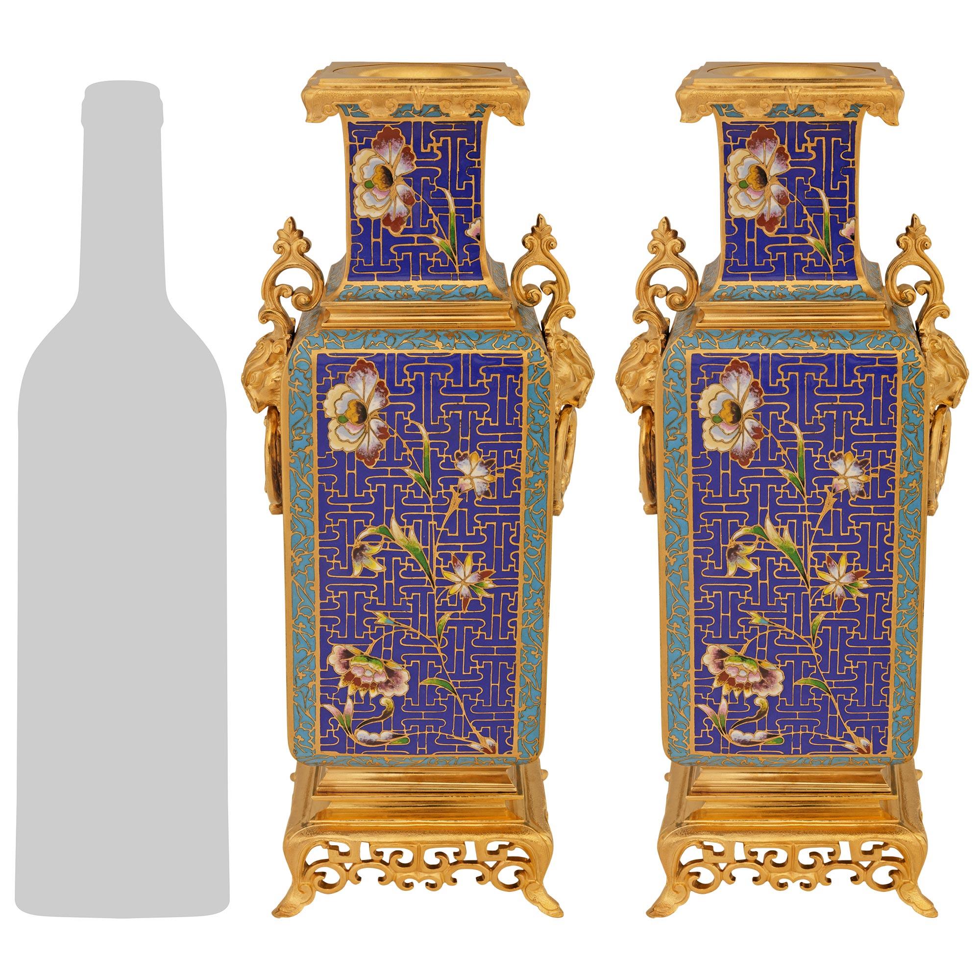 Una coppia di vasi in cloisonné e ormolu del XIX secolo, di charme e di alta qualità. Ogni splendido vaso è sollevato da una base quadrata traforata in Ormolu che sostiene il vaso Cloisonné sontuosamente dettagliato con motivi geometrici in cobalto