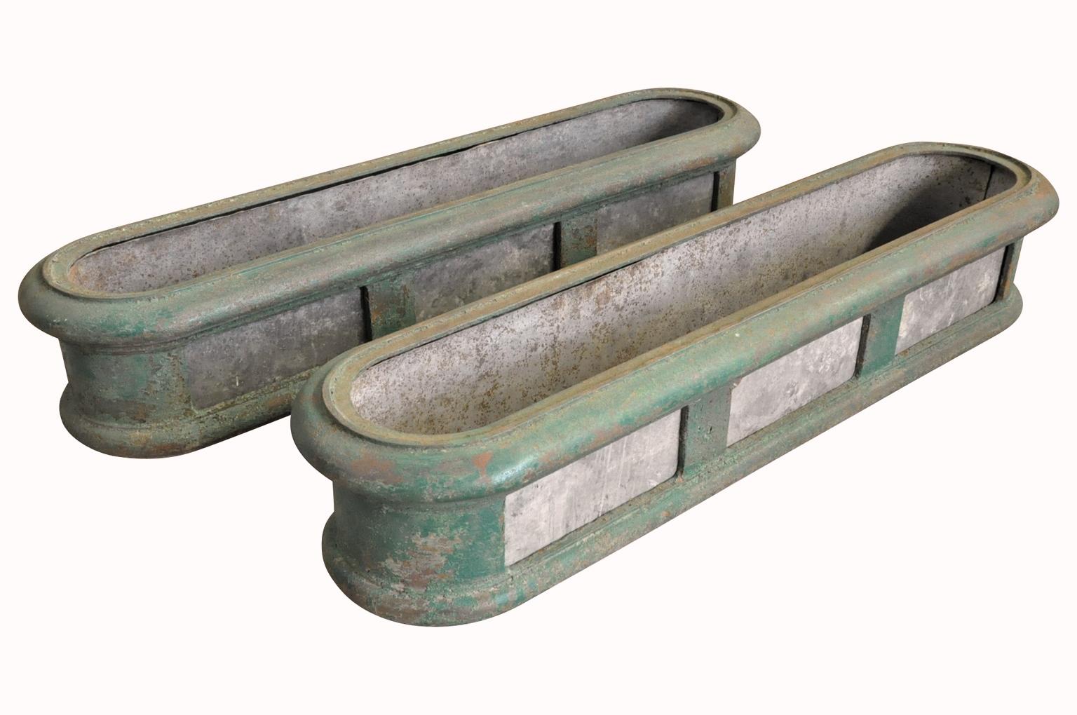 A wonderful pair of 19th century oblong shape jardinières - planters soundly constructed from painted cast iron and zinc. Terrific shape and terrific patina. Wonderful for any interior or garden.