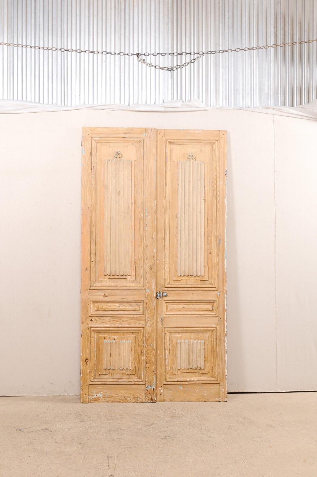 A beautiful pair of French linenfold carved doors from the 19th century. This pair of French three-panel doors each feature a sweetly carved linenfold design at upper and lower panels, with back-sides being adorn in more of a geometric pattern