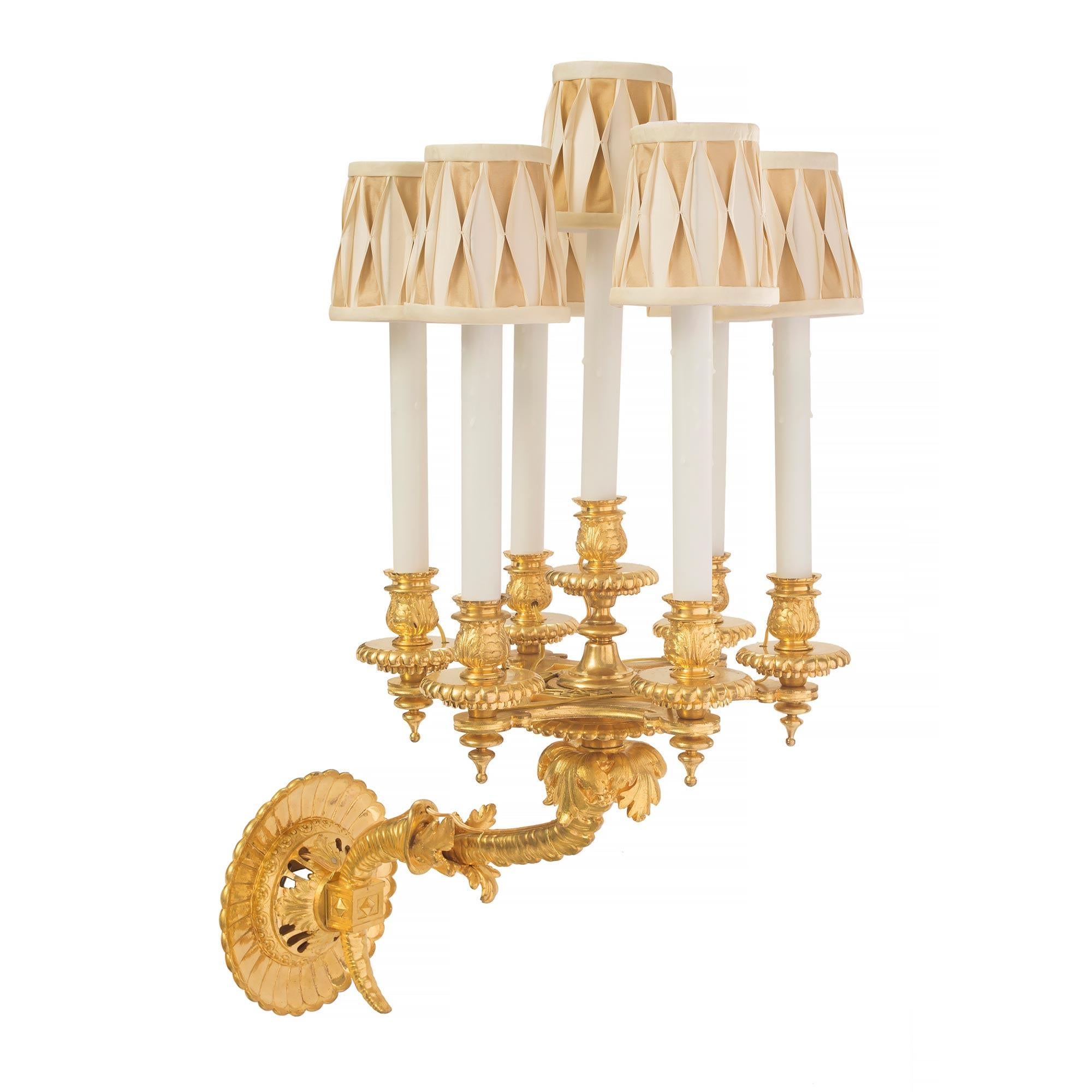 A stunning pair of French 19th century Louis Philippe St. seven-arm ormolu sconces. Each sconce displays a most decorative reeded back plate and an elegant scrolled support, in the shape of a cornucopia, has finely detailed foliate accents. Each arm