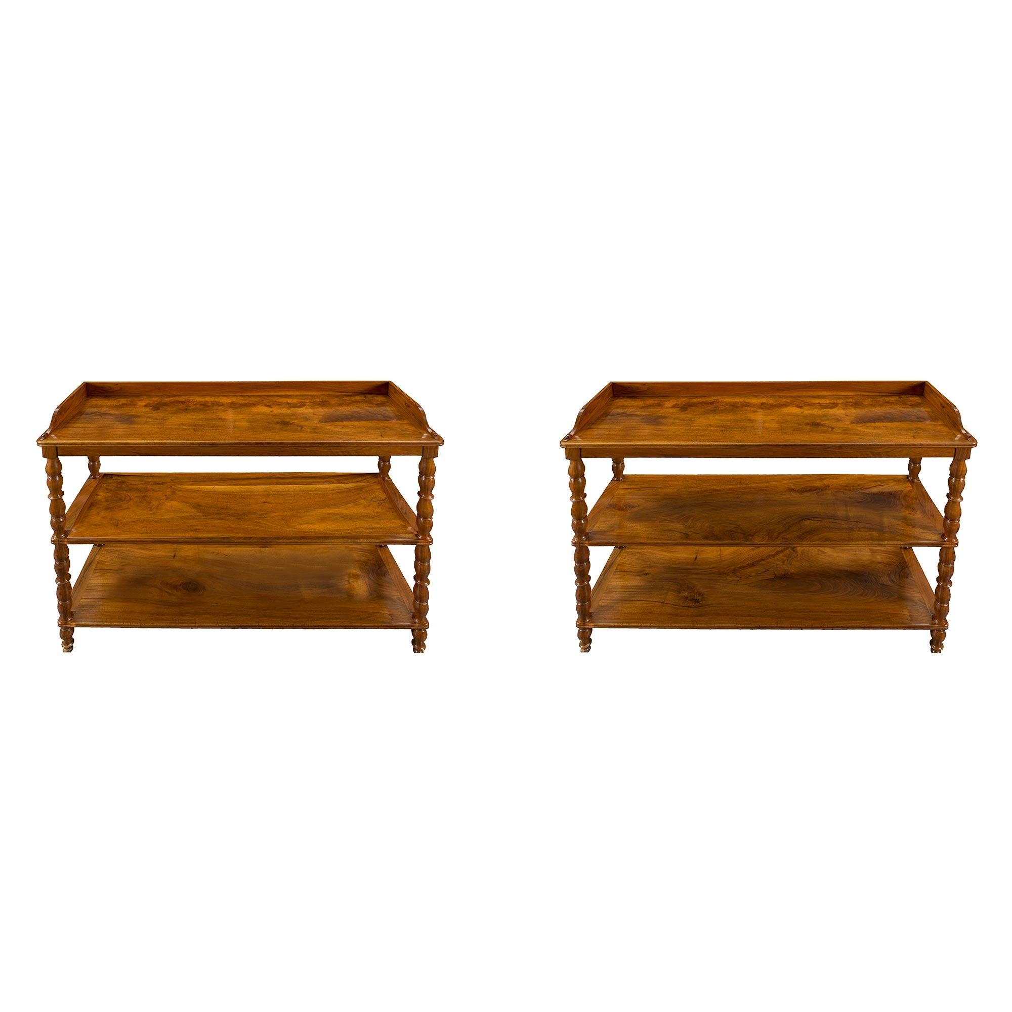 A superb pair of French 19th century Louis Philippe st. walnut étagères. Each étagère is raised by elegant turned legs that continue up each side. The three shelves display a mottled border and fine grain throughout. The top shelf is bordered with a