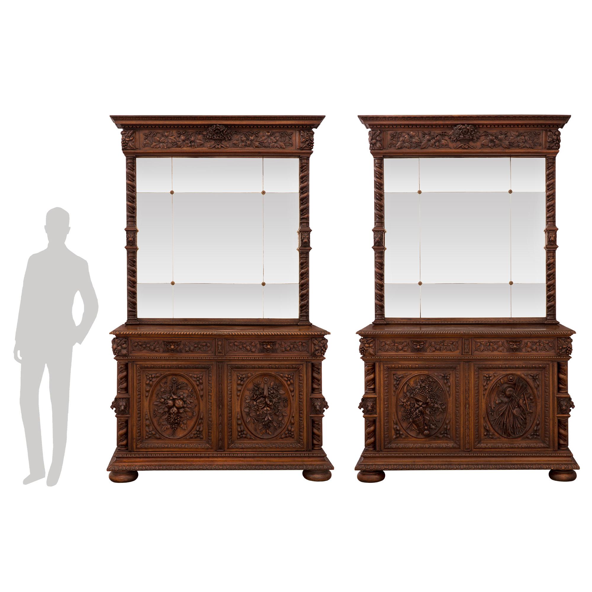 A spectacular and most impressive pair of French 19th century Louis XIII st. walnut buffets with their matching mirrors depicting the four seasons. Each buffet is raised by bun feet below an elegant carved floral band. At the center of each buffet