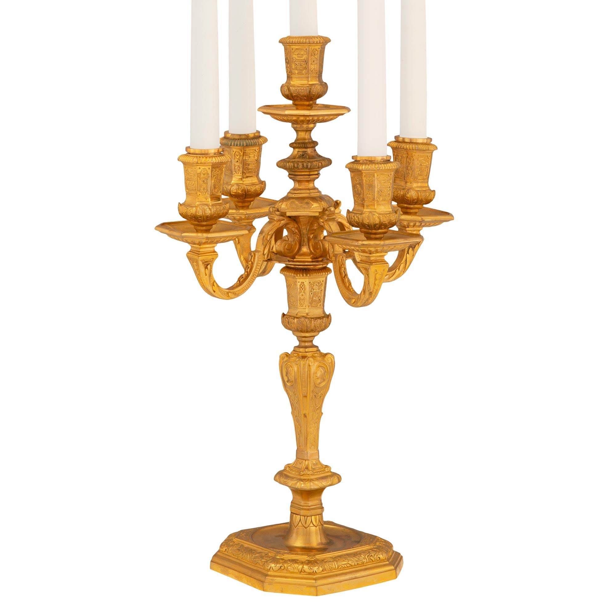 An elegant and high quality pair of French 19th century Louis XIV st. ormolu candelabras. Each five arm candelabra is raised on a square base with lovely cut corners and a richly chased mottled wrap around foliate band. The beautiful baluster shaped