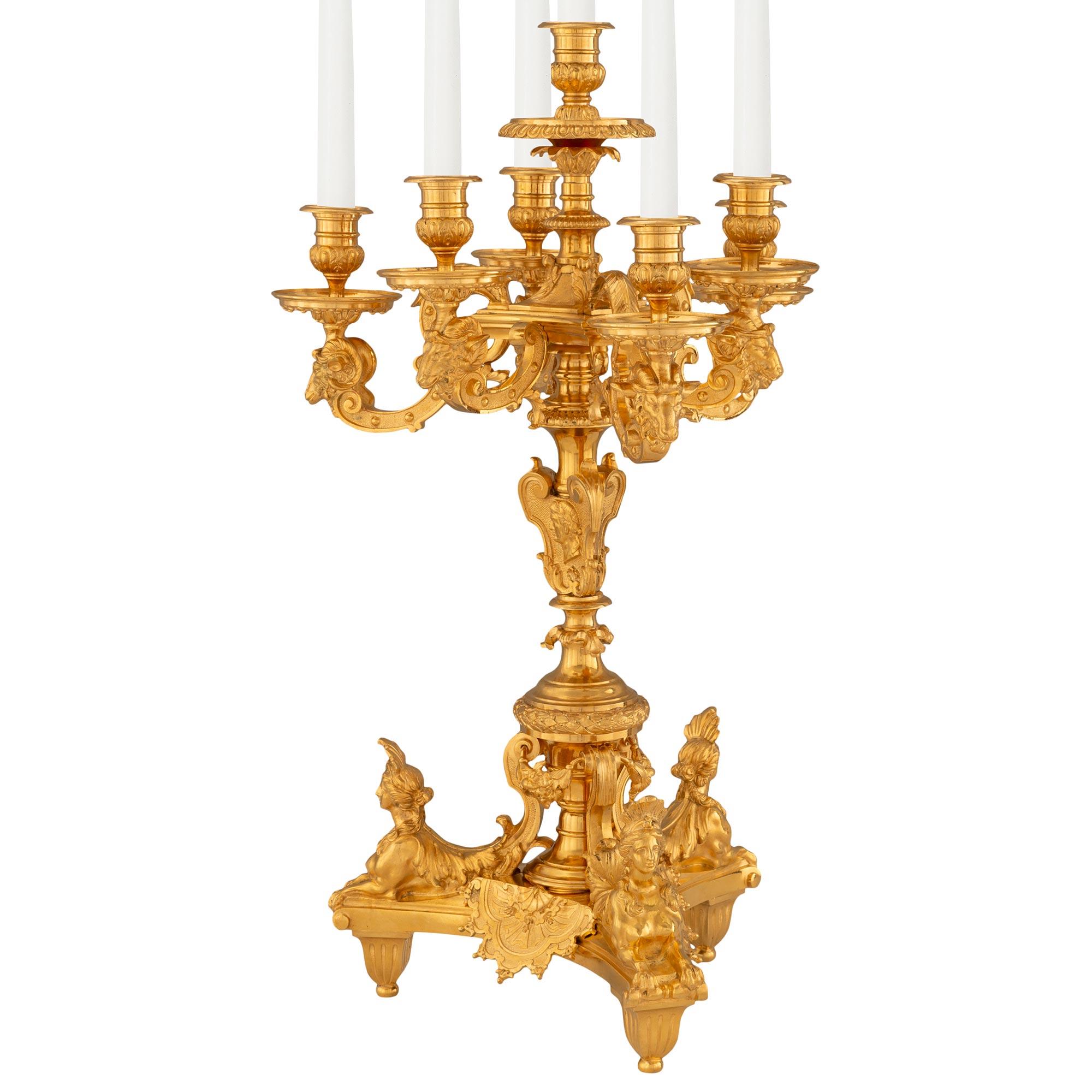 A striking and most impressive pair of French 19th century Louis XIV st. ormolu candelabras. Each seven arm candelabra is raised by a triangular base with three delicate tapered fluted feet below exceptional richly chased sphinges with acanthus