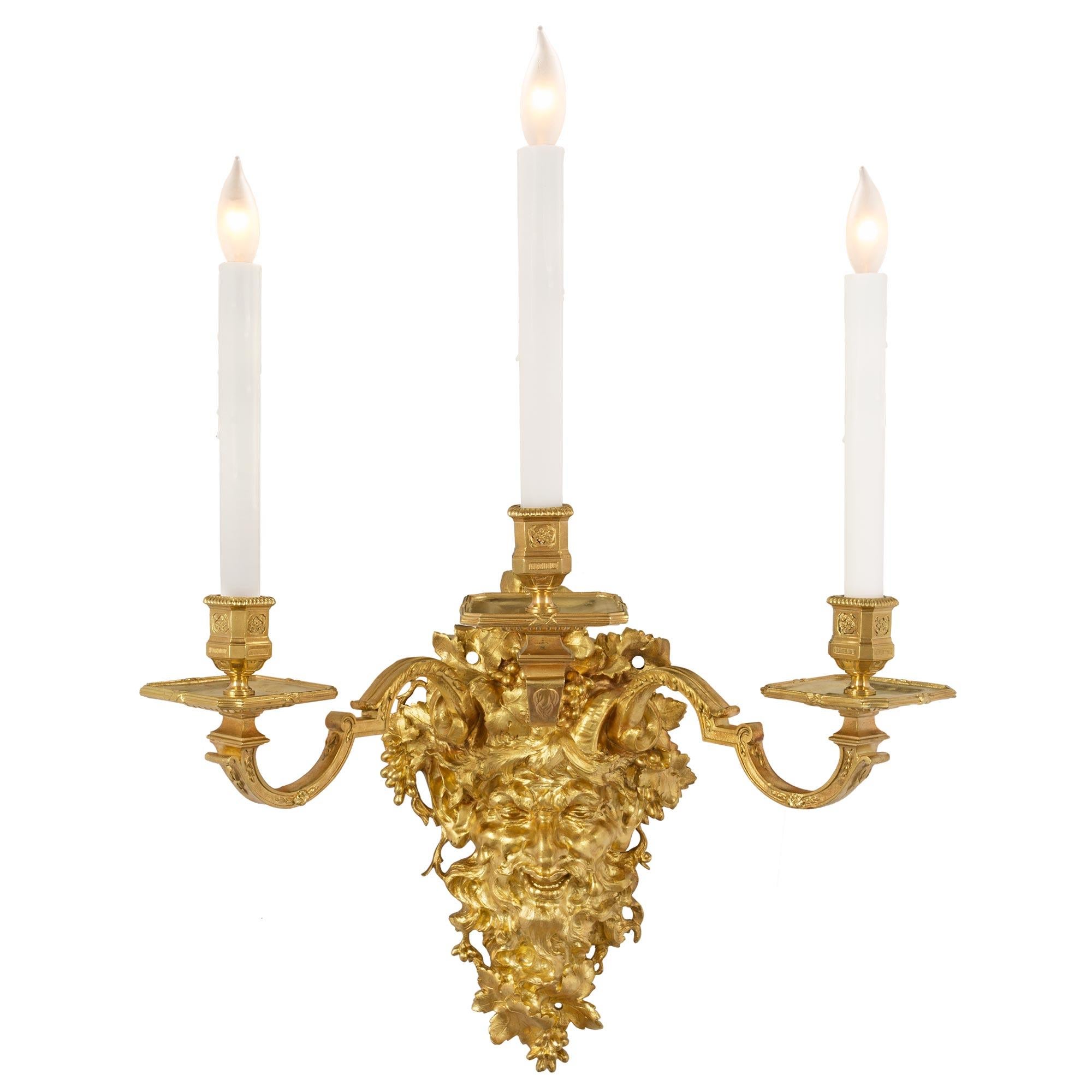 A spectacular and most impressive large scale pair of French 19th century Louis XIV st. ormolu three-arm sconces. The fanciful and expressive back plate is of a grinning satyr. The satyr is surrounded by richly detailed grape clusters and vines. The