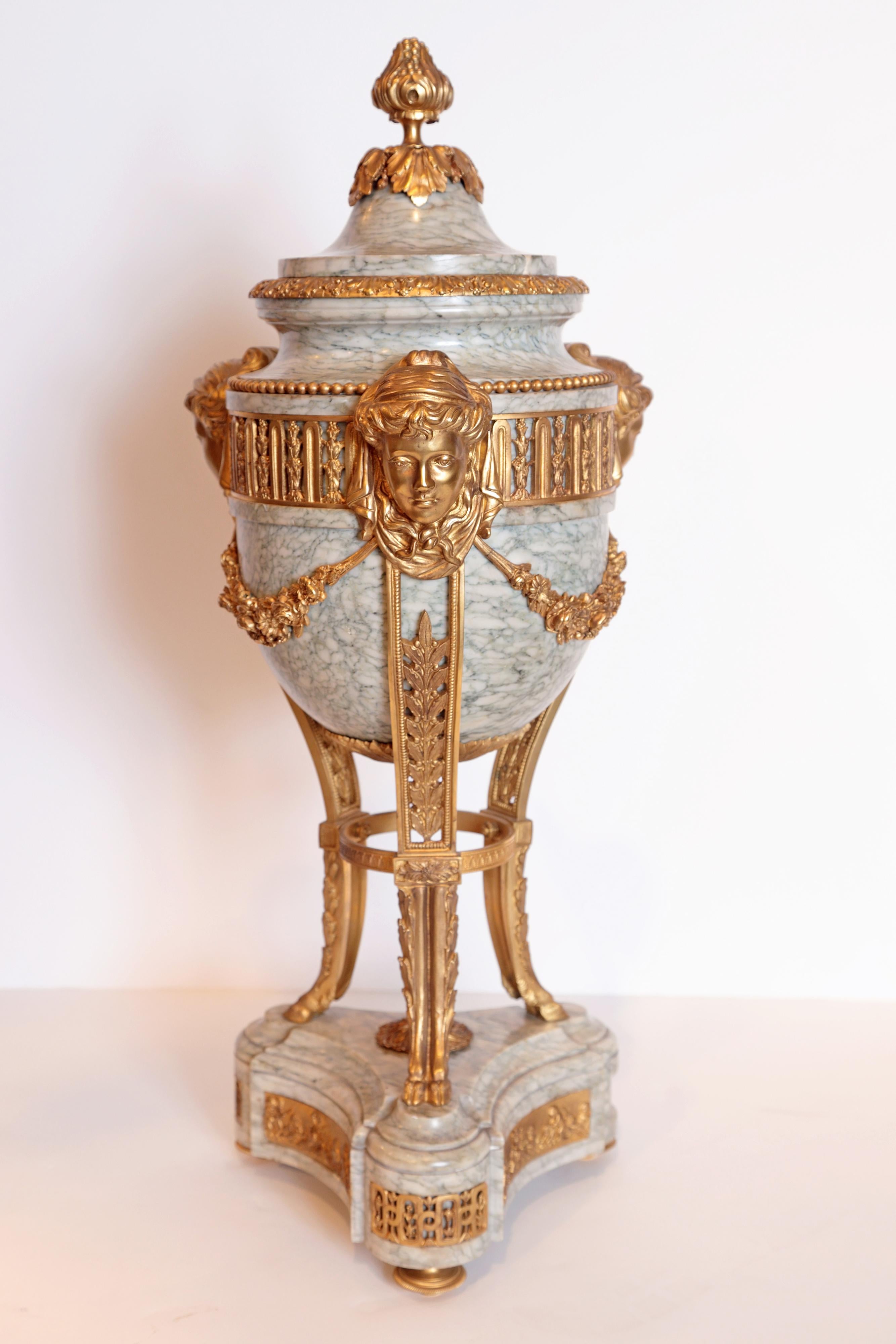 Pair of French marble and gilt bronze Louis XV lidded urns. Female faces with tripod gilt bronze hoofed foot design.