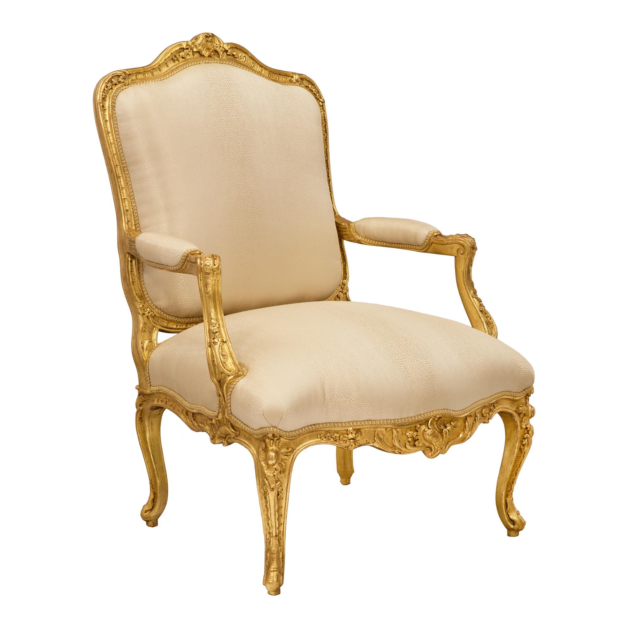 Une superbe paire de fauteuils français du 19ème siècle en bois doré de style Louis XV. Chaque chaise est surélevée par d'élégants pieds cabriole décorés de détails feuillagés richement sculptés. La frise en forme d'arbalète est centrée par de