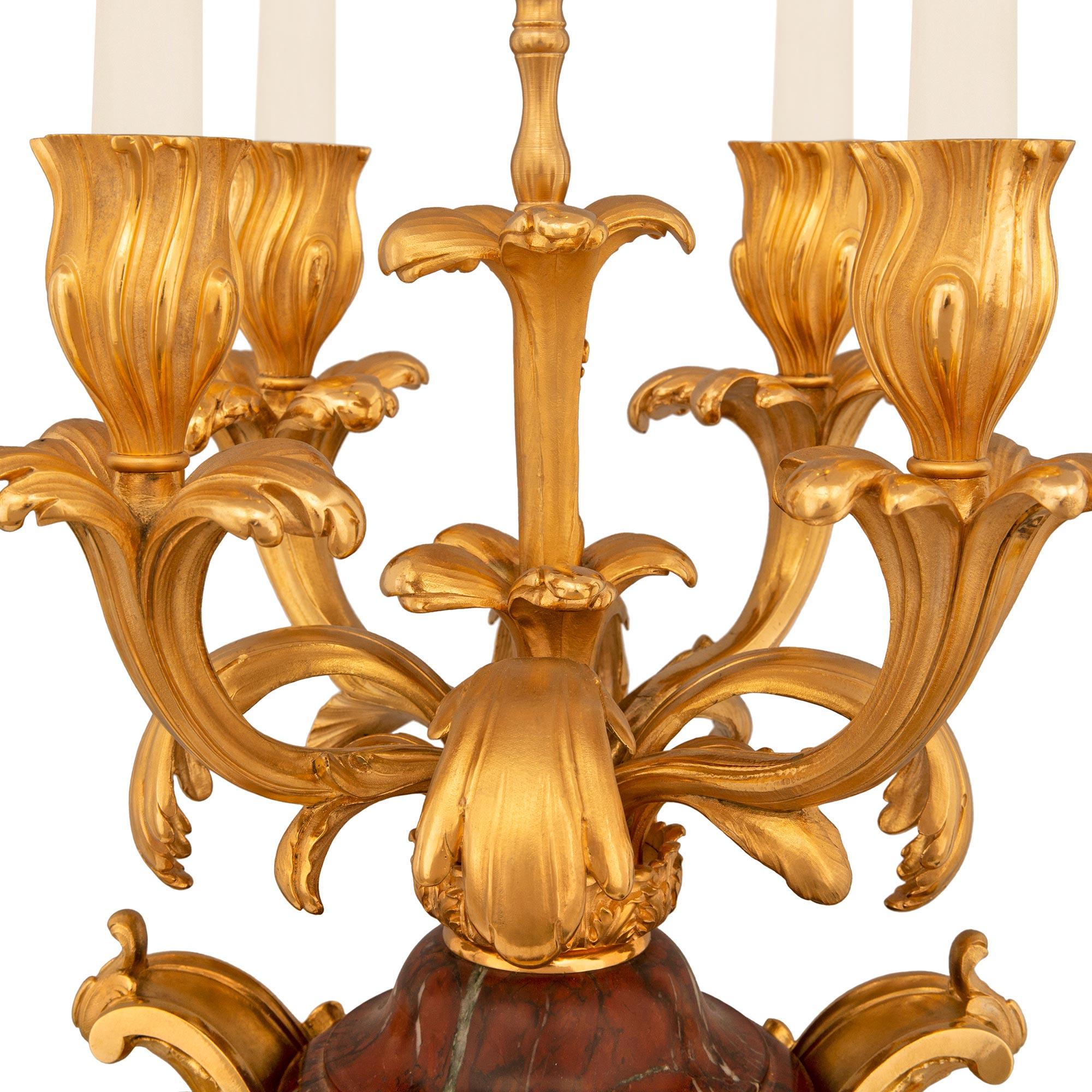 An extremely high quality and palatially scaled pair of French 19th century Belle Epoque Period Louis XV st. Rouge Griotte marble and Ormolu candelabras, attributed to F. Barbedienne. These exquisite four arm candelabras are raised by square bases