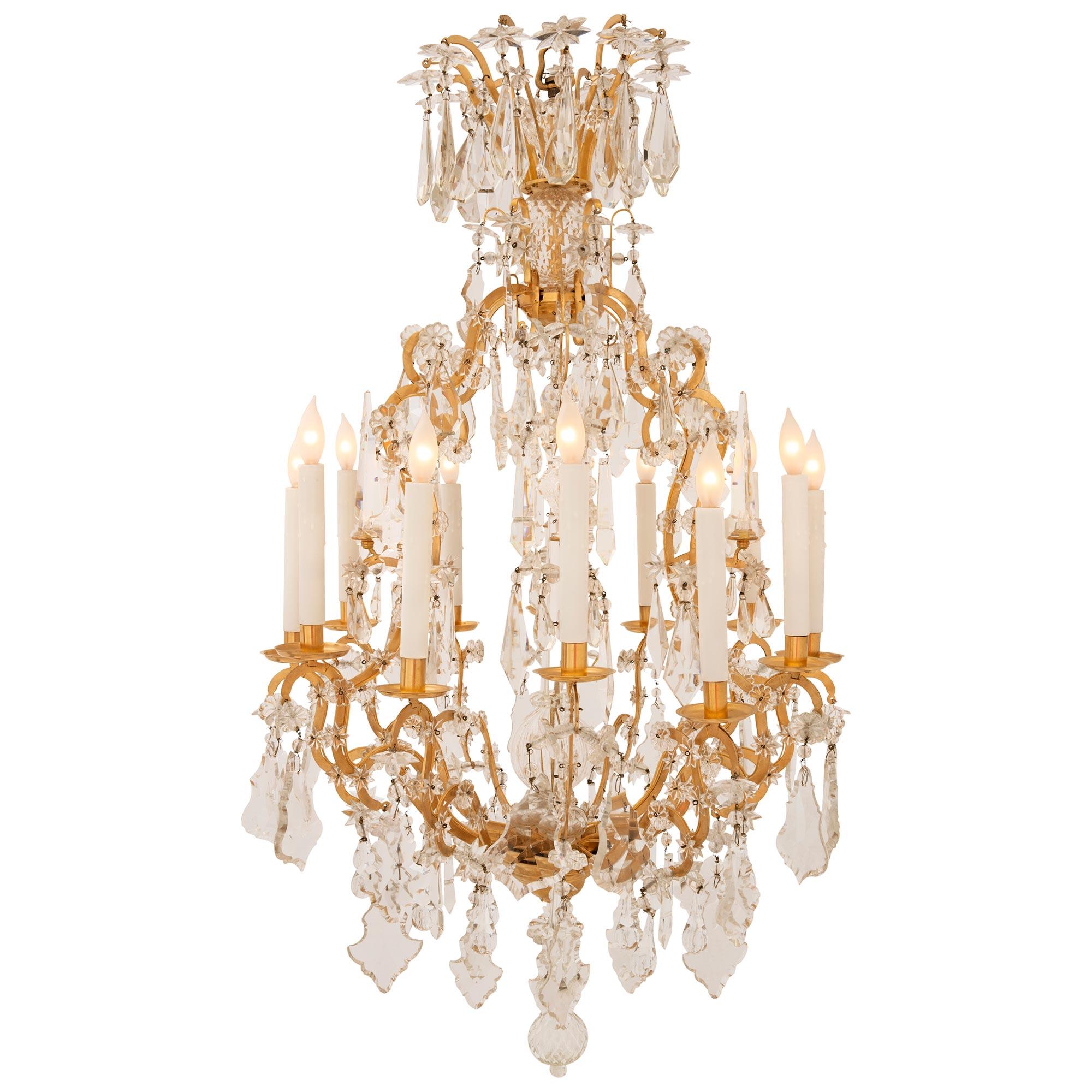 A stunning pair of French 19th century Louis XV st. ormolu and Baccarat crystal chandeliers. Each twelve arm chandelier is centered by a beautiful and most uniquely shaped hand blown crystal pendant amidst a stunning array of cut crystals and