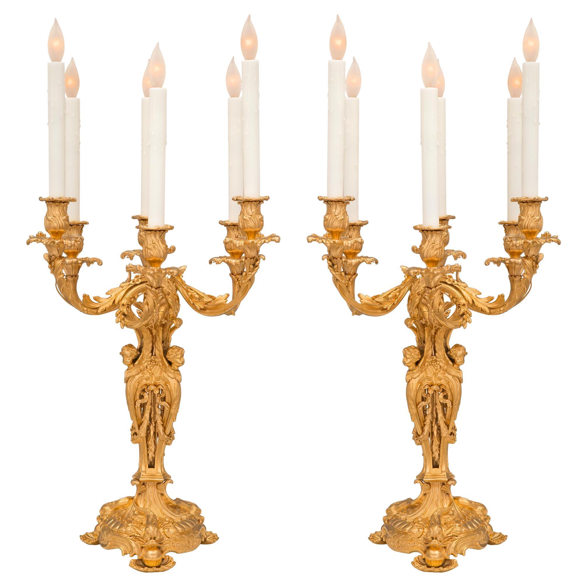 Une paire exceptionnelle et de très haute qualité de lampes candélabres en bronze doré de style Louis XV du 19ème siècle attribuées à François Linke. Chaque lampe à six bras est surélevée par une étonnante base circulaire feuillagée et