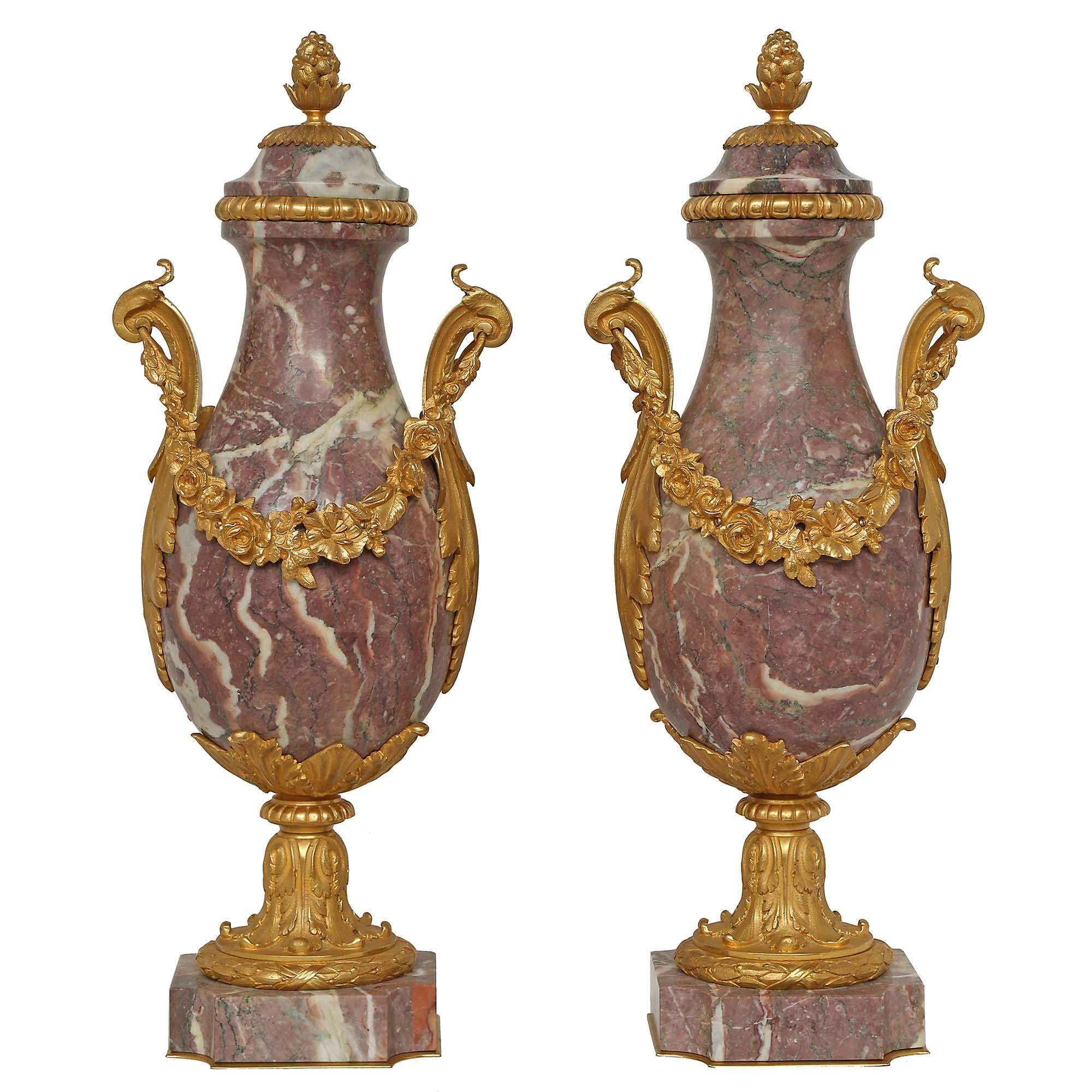 A pair of impressive French mid 19th century Louis XV st. ormolu and Rouge Royale marble cassolettes. The marble bases are ornamented with ormolu acanthus leaf designs. Each with two handles in the shape of S scrolls and acanthus leaf designs. The