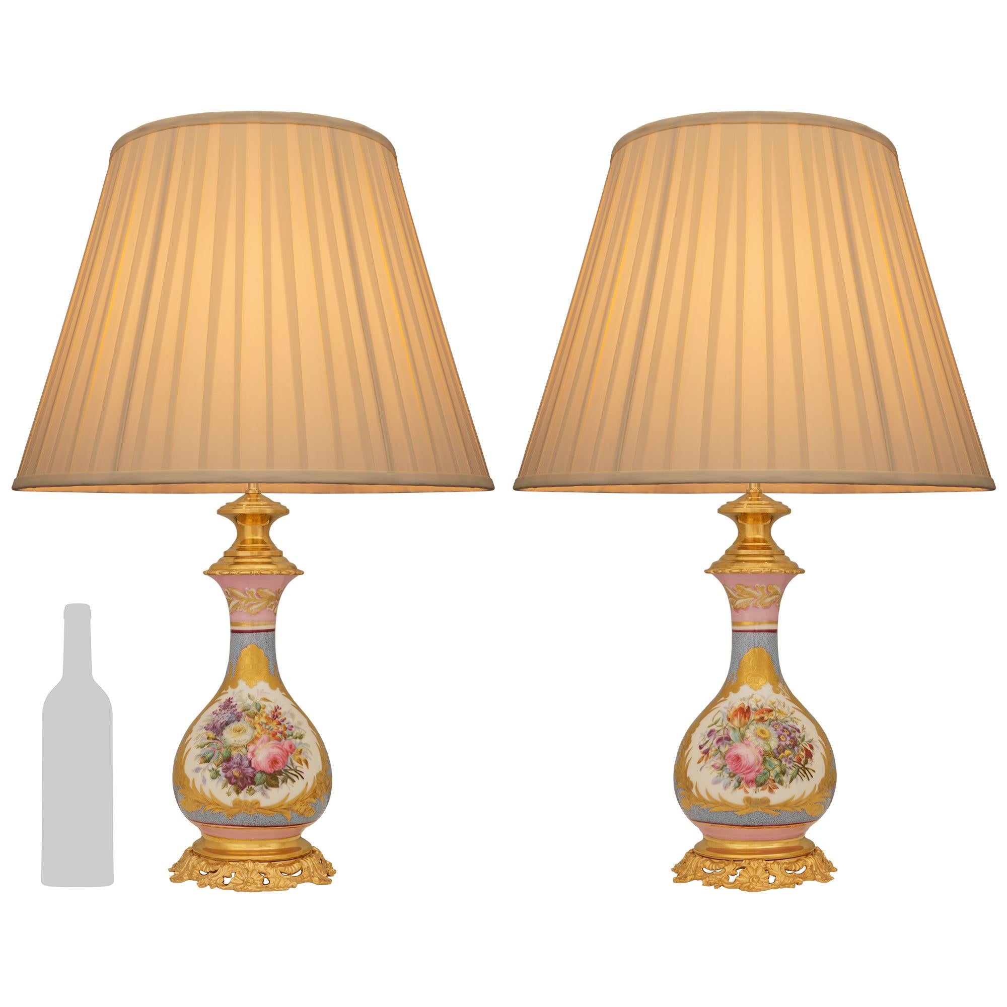 Una coppia elegante e ricca di dettagli di lampade francesi del XIX secolo in porcellana e ormeggio di Sévres. Ogni elegantissimo vaso montato in una lampada è sollevato da una base in Ormolu con fogliame traforato che sostiene i vasi in porcellana