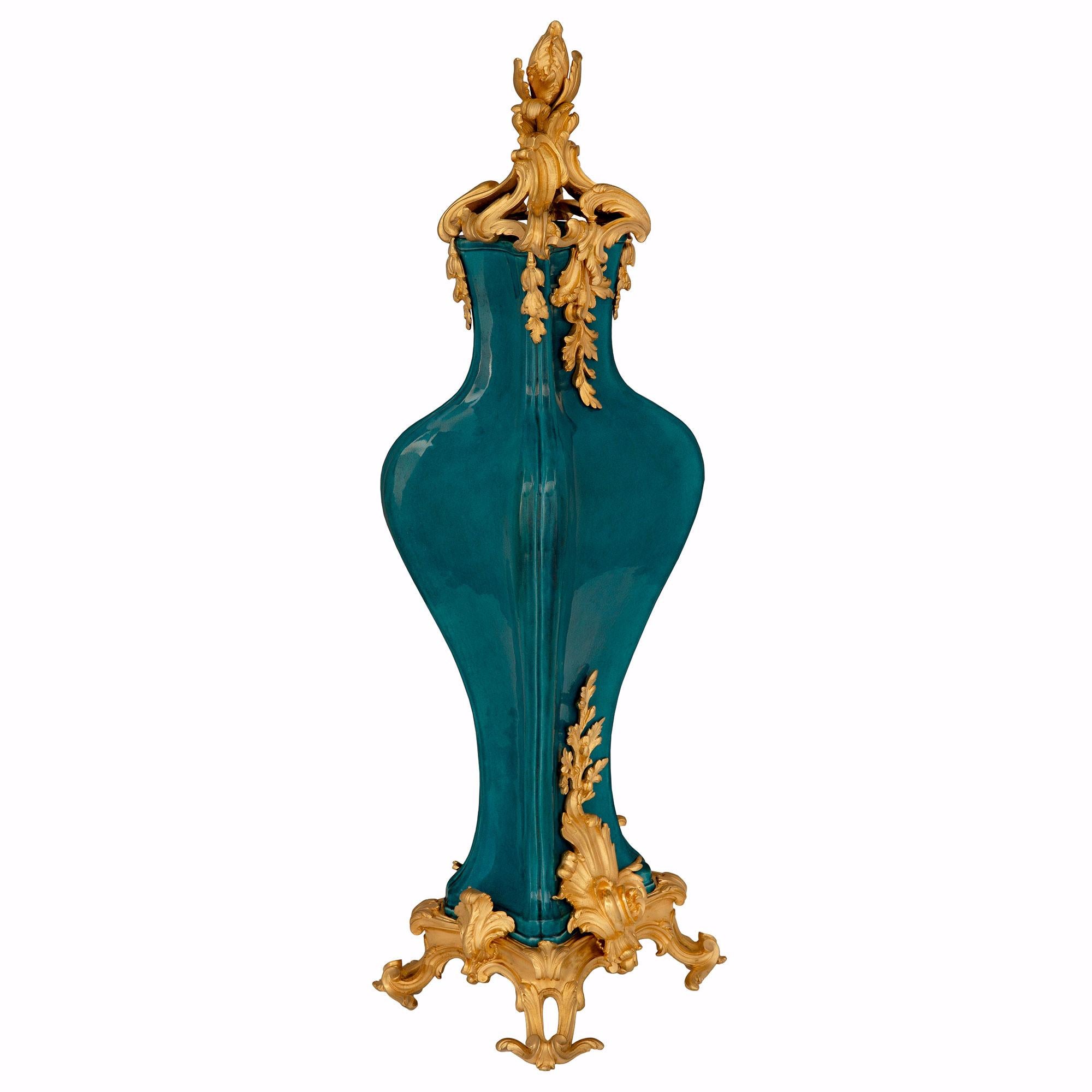 A sensational and large scale true pair of French 19th century Louis XV st. Belle Époque period ormolu and porcelain vases, attributed to François Linke. Each lidded vase is raised by elegant pierced scrolled foliate feet below a luxuriant richly