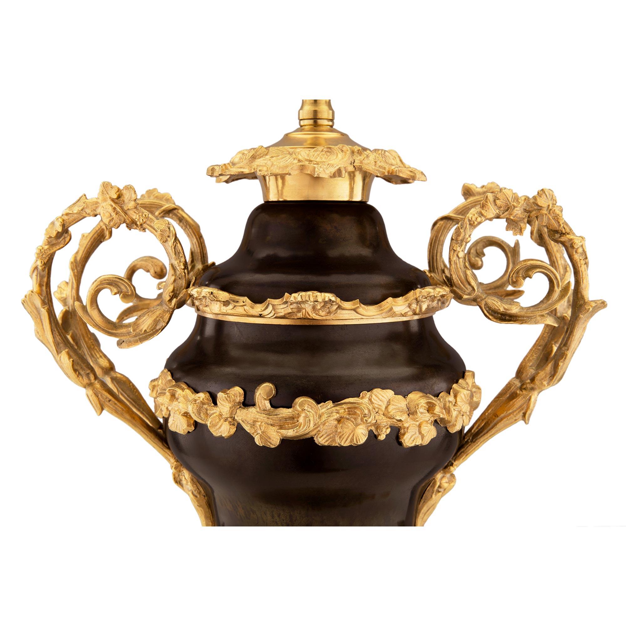 Paar französische Bronze- und Goldbronze-Lampen im Louis-XV-Stil des 19. Jahrhunderts (Patiniert) im Angebot