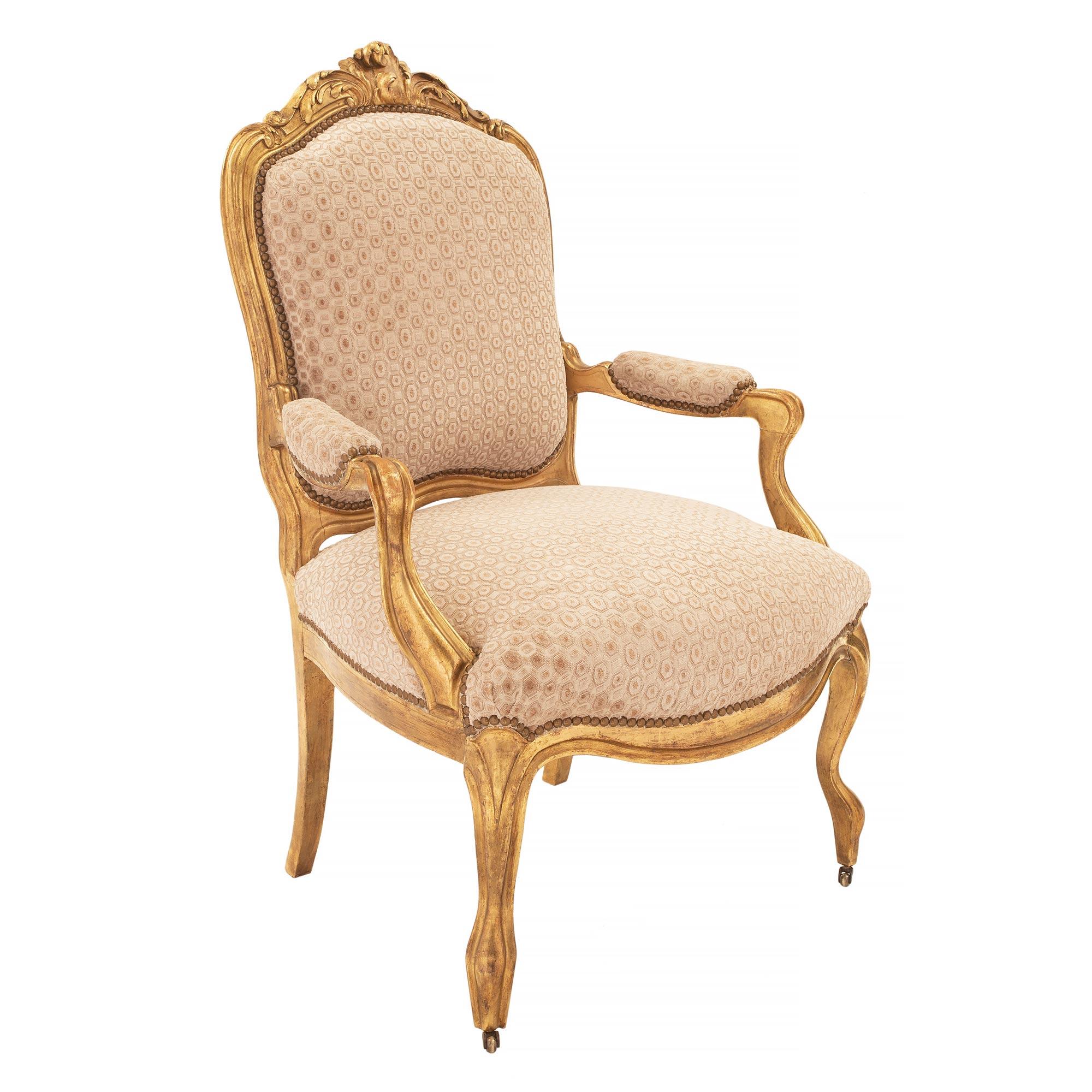 A most elegant pair of French 19th century Louis XV st. giltwood armchairs. Each chair is raised by fine cabriole legs with a decorative mottled band which extends along the arbalest shaped frieze and sides. Each cushioned arm rest displays a
