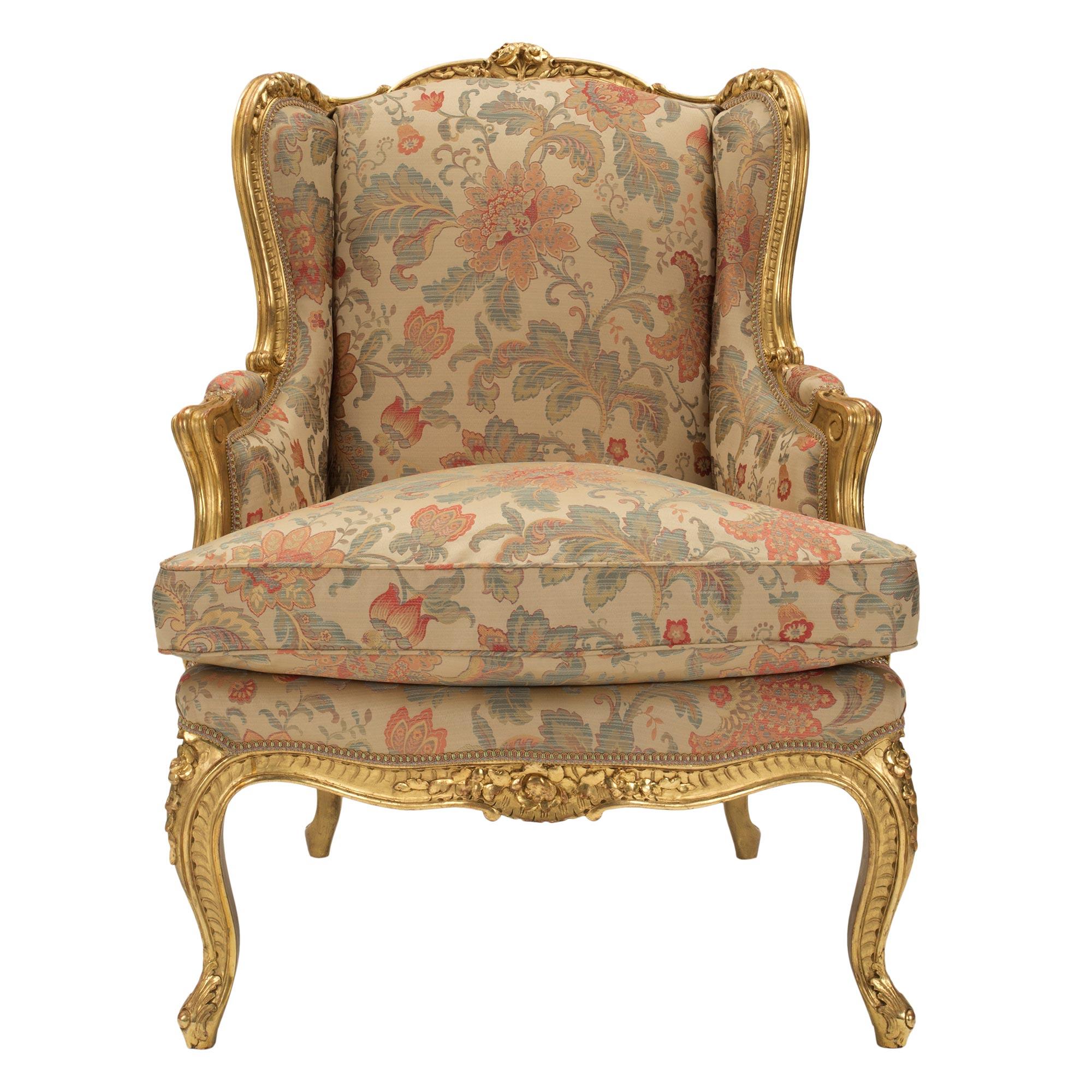 An exceptional pair of French 19th century Louis XV st. giltwood bergères a oreilles. Each armchair is raised by beautiful cabriole legs with fine acanthus leaf feet and a unique and most decorative carved pattern which extends along the arbalest