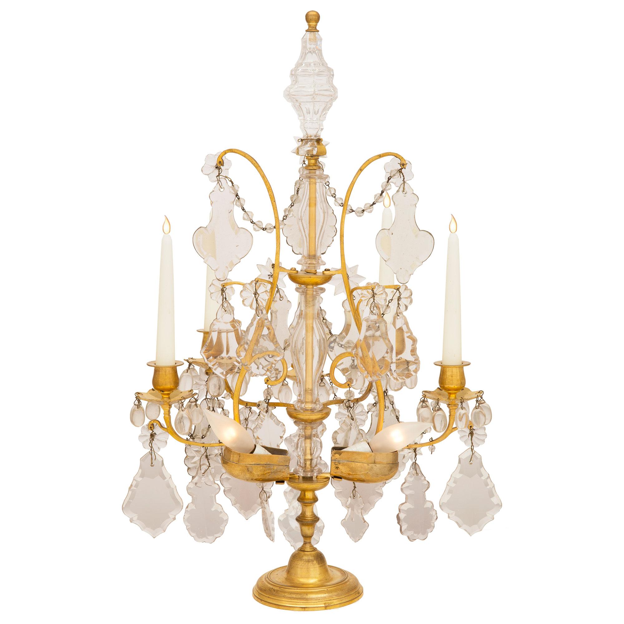 An elegant pair of French 19th century Louis XV st. electrified Baccarat crystal and ormolu Girandole lamps. Each five arm, two light lamp is raised by a fine circular ormolu base with a lovely mottled design and fine turned shaped central futs. At
