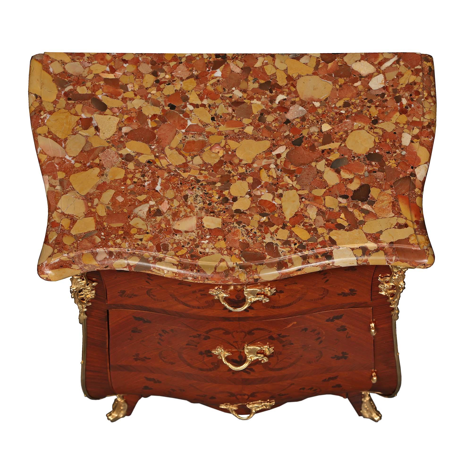A lovely pair of French 19th century Louis XV style kingwood and tulipwood marquetry bombée chests. Each chest is raised by short cabriole legs with fine ormolu sabots that lead up to elegant richly chased pierced ormolu foliate corner mounts. The