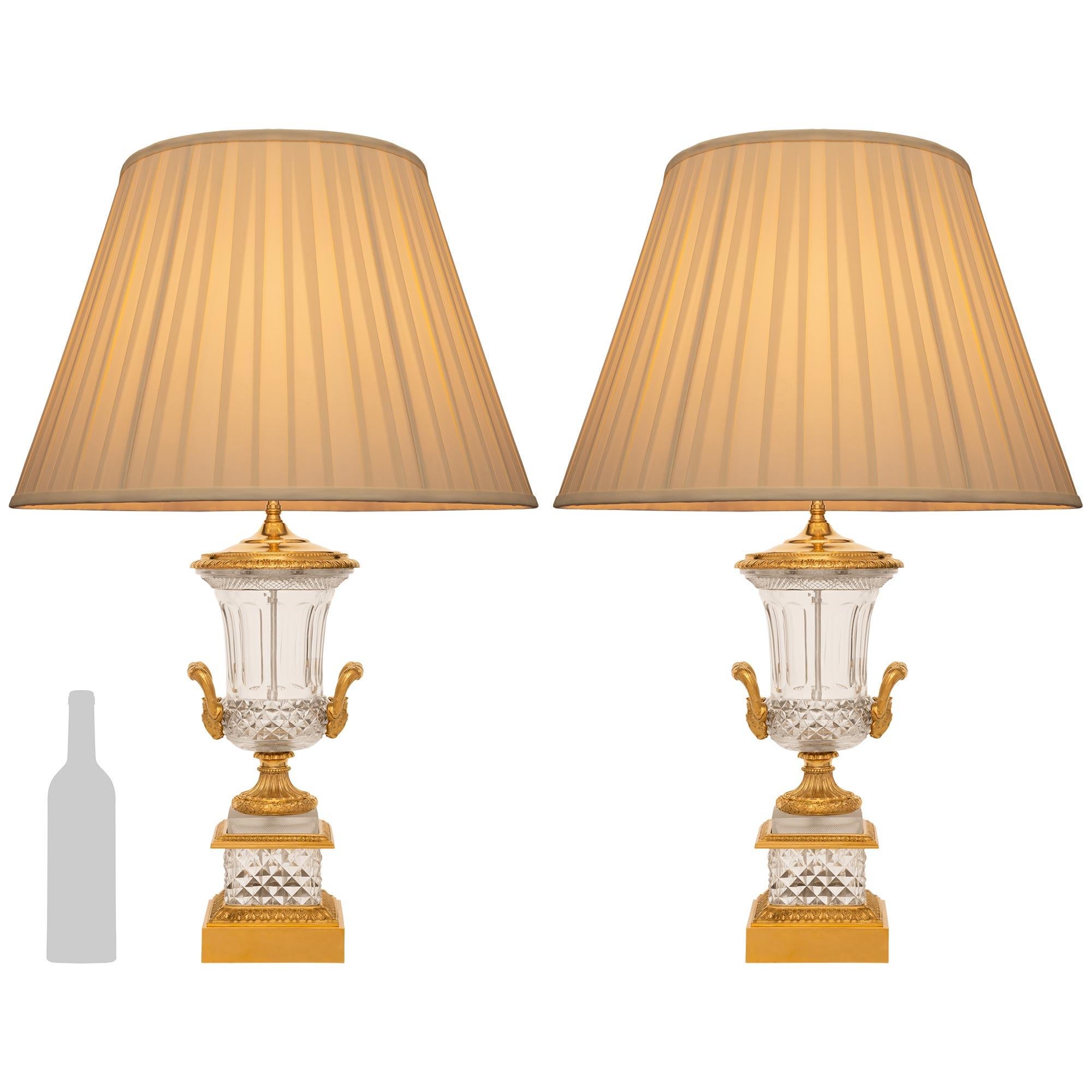 A high quality and most elegant pair of French 19th century Louis XVI st. Baccarat Crystal and Ormolu lamps. Each lamp is raised on a square Ormolu plinth displaying a Coeur-de-Rai band below a lattice cut Crystal pedestal. An elegant central Ormolu